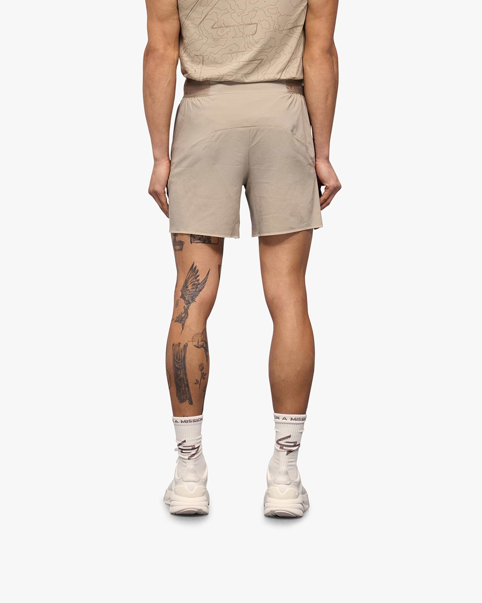 Man wearing grey shorts on a plain white background | Team 247 Aero Shorts in Pebble | Lightweight breathable running shorts | 247 Shorts | Represent Clo