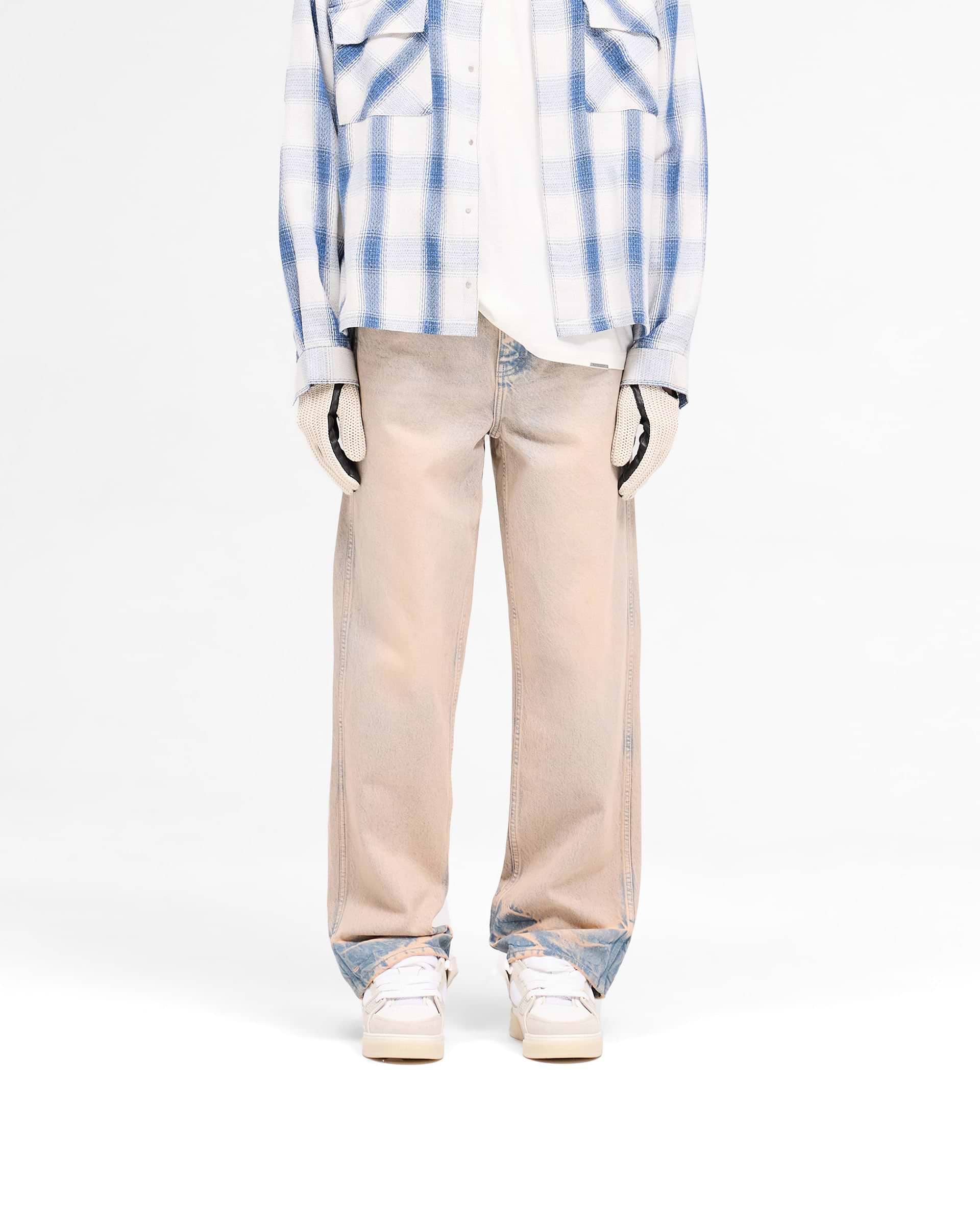 Man wearing blue jeans on a plain white background | R3 Baggy Denim in Dusk | Baggy fit denim with a heavy wash and signature embroidery | SS25 Denim | Represent Clo