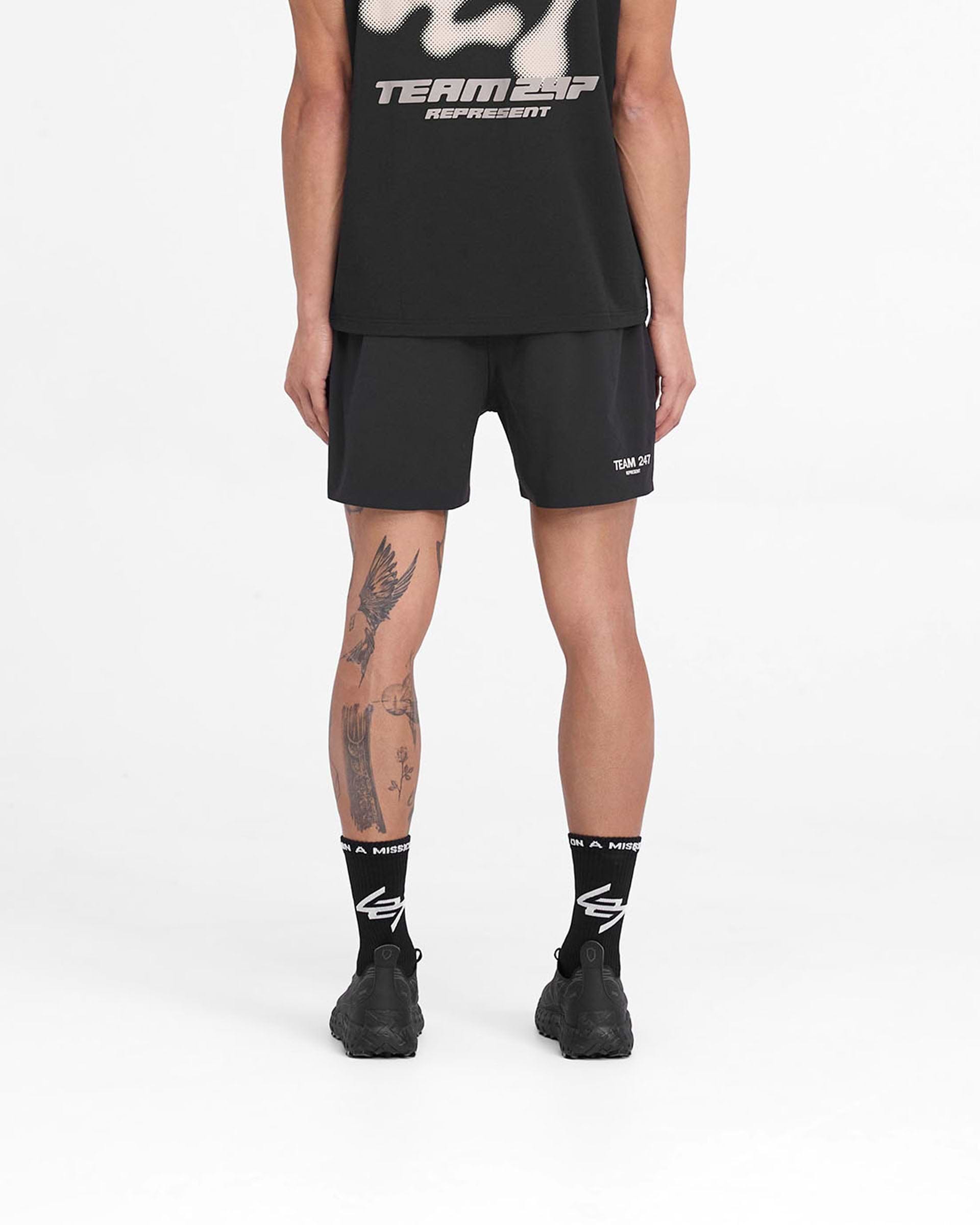 Man wearing black shorts on a plain white background | Team 247 Fused Shorts in Black | Shorts with branded waistband and 4-way stretch | 247 Shorts | Represent Clo