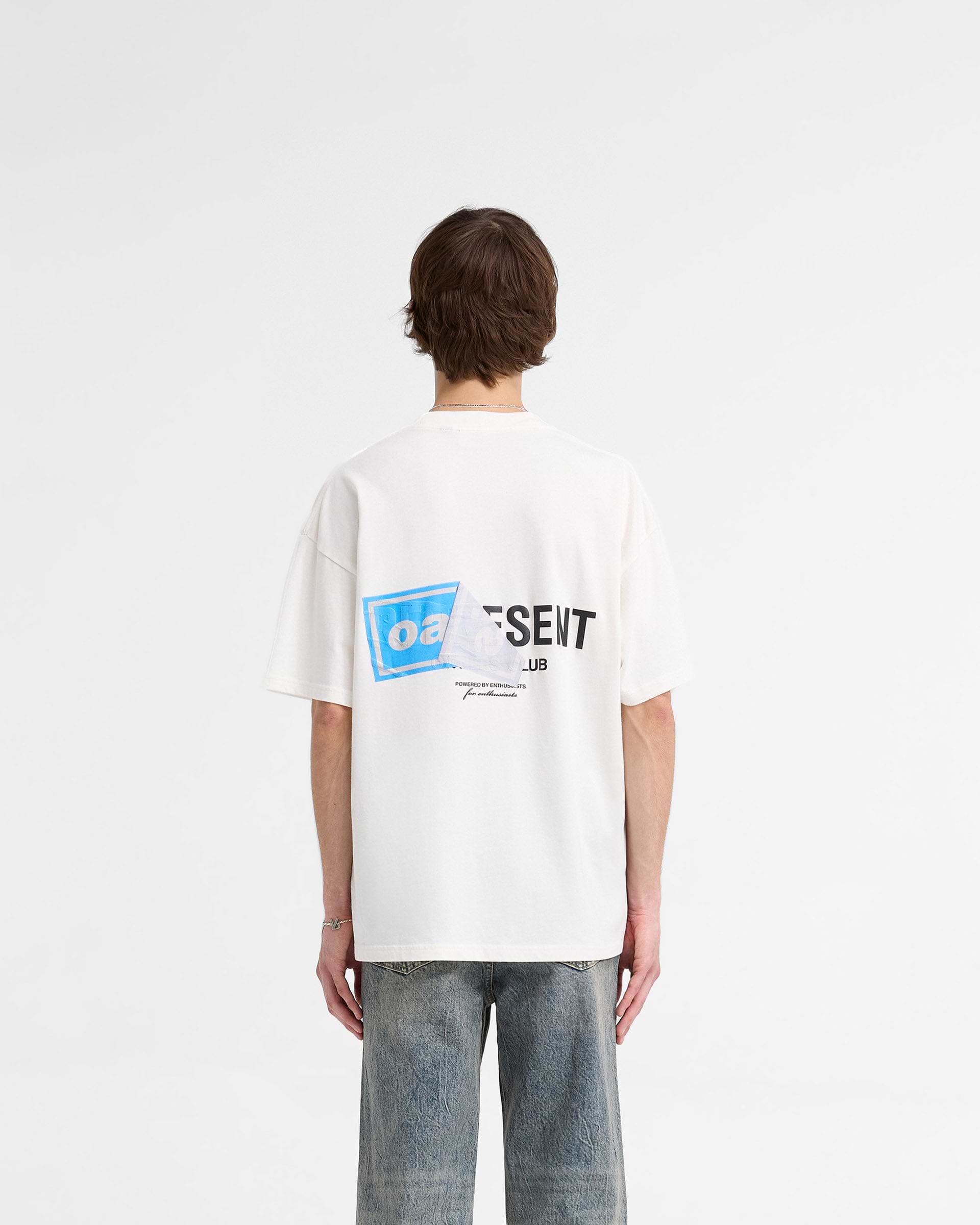 Man wearing a white t-shirt with graphic print on a plain white background | Represent X Oasis Owners Club T-Shirt in Flat White | Oversized fit t-shirt with Oasis artwork and Owners Club branding | FW24 T-Shirts | Represent Clo