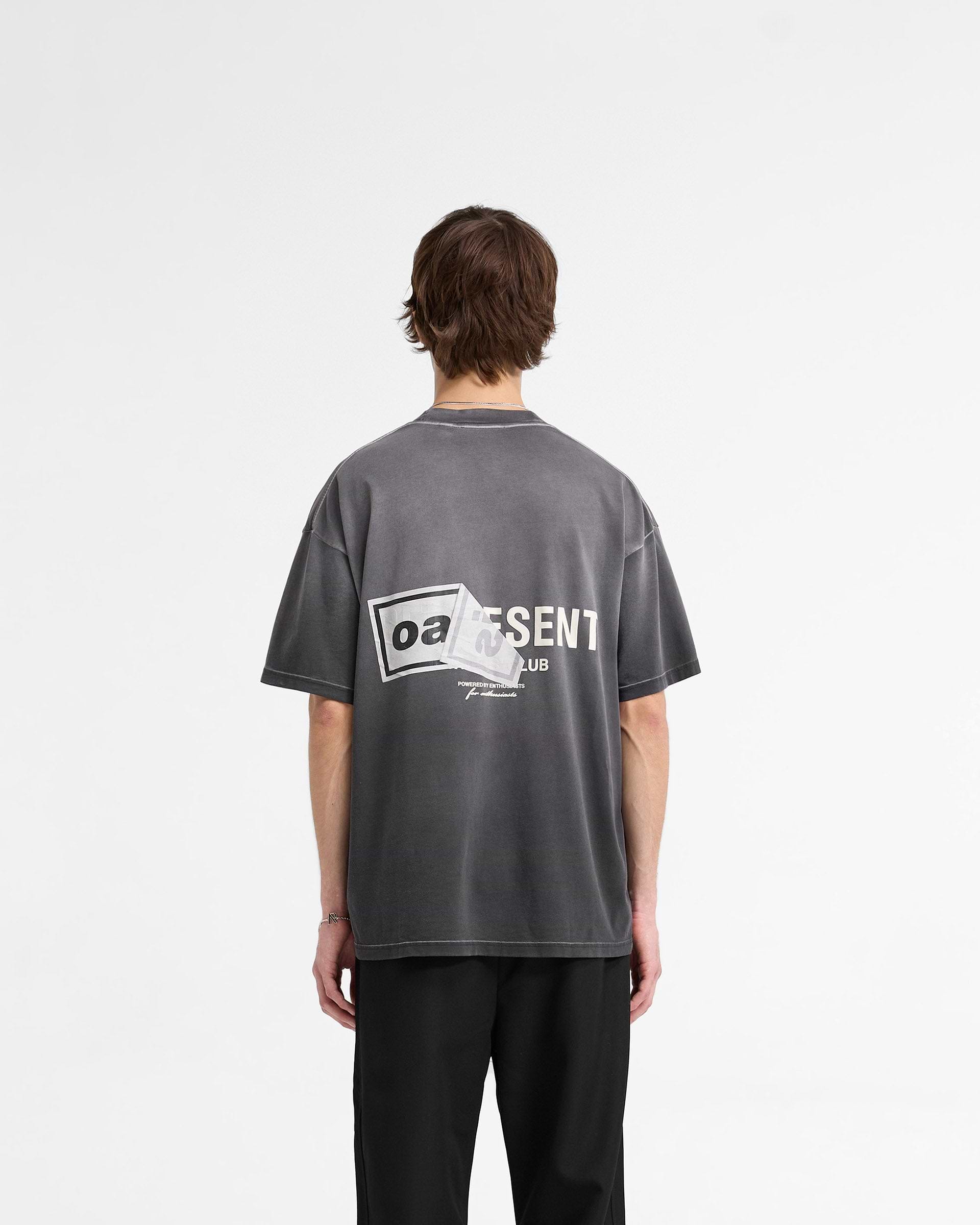 Man wearing a black t-shirt on a plain white background | Represent X Oasis Owners Club T-Shirt in Stained Black | Oversized fit t-shirt with dual logo and fly postered artwork | FW24 T-Shirts | Represent Clo