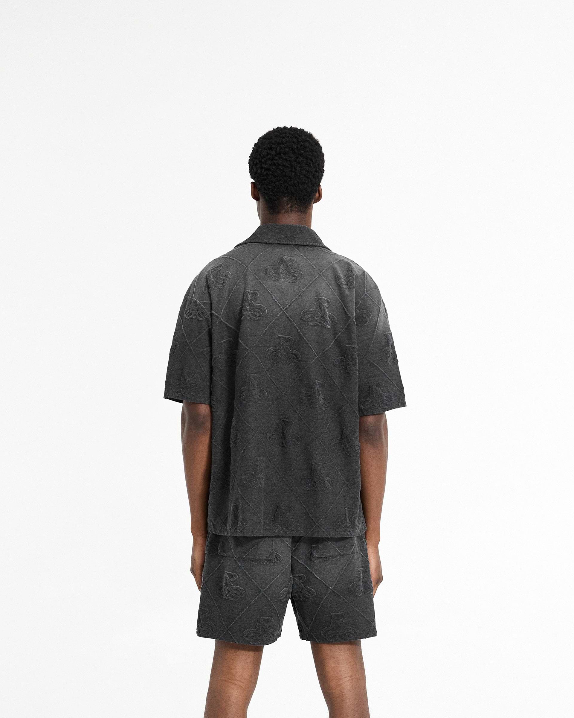 Man wearing a black shirt on a plain white background | Towelling Shirt in Jet Black | Oversized shirt with popper fastenings | SC24 Shirts | Represent Clo
