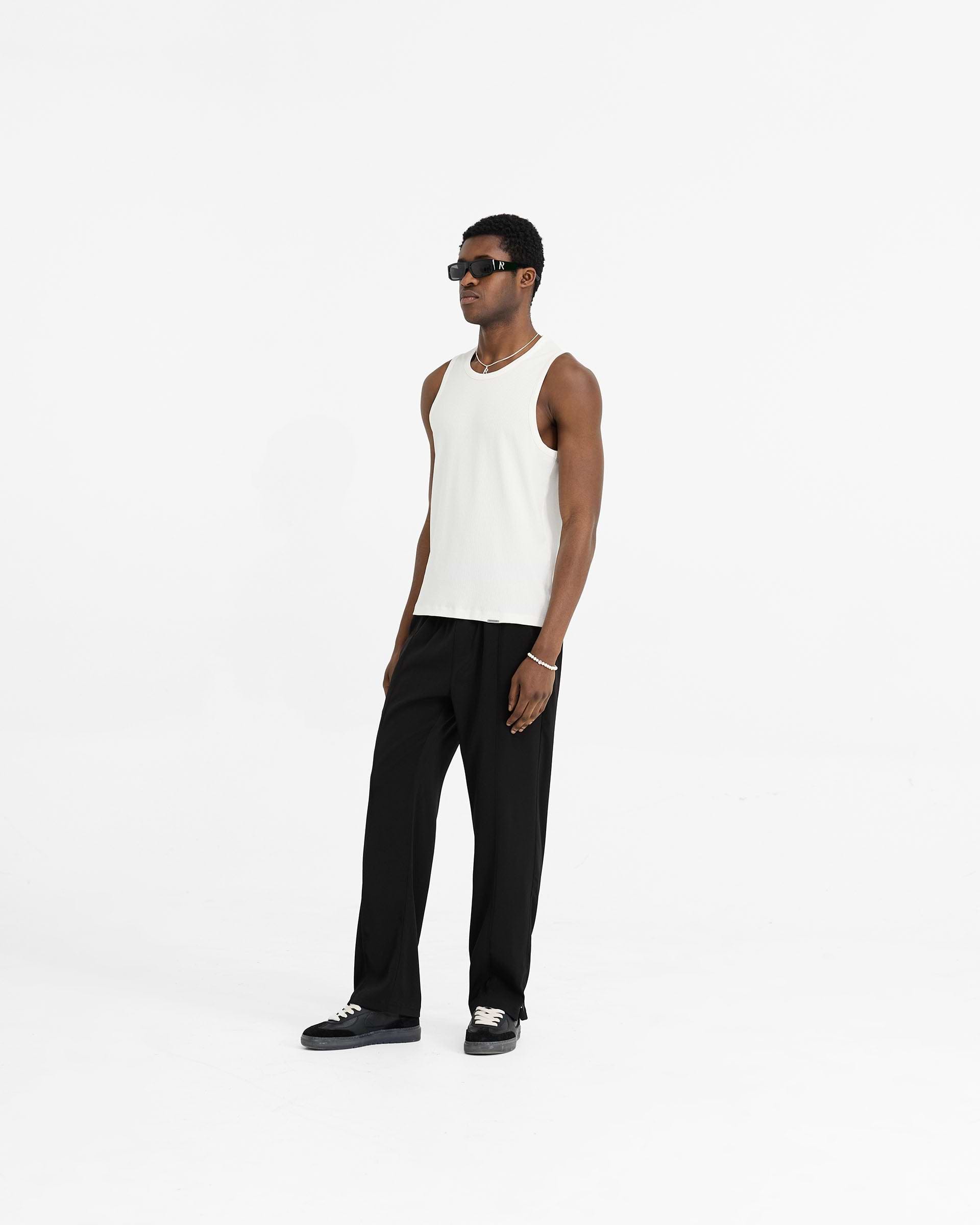 Man wearing a white rib vest on a plain white background | Initial Rib Vest in Flat White | Rib vest with regular fit and embroidered details | Initial T-Shirts | Represent Clo