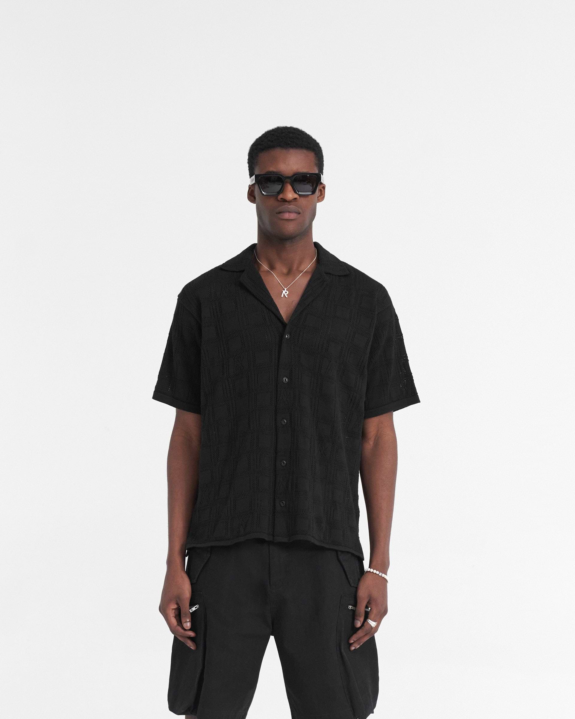 Man wearing a black lace knit shirt on a plain white background | Lace Knit Shirt in Black | Oversized fit with crochet pattern and revere collar | SS24 Shirts | Represent Clo