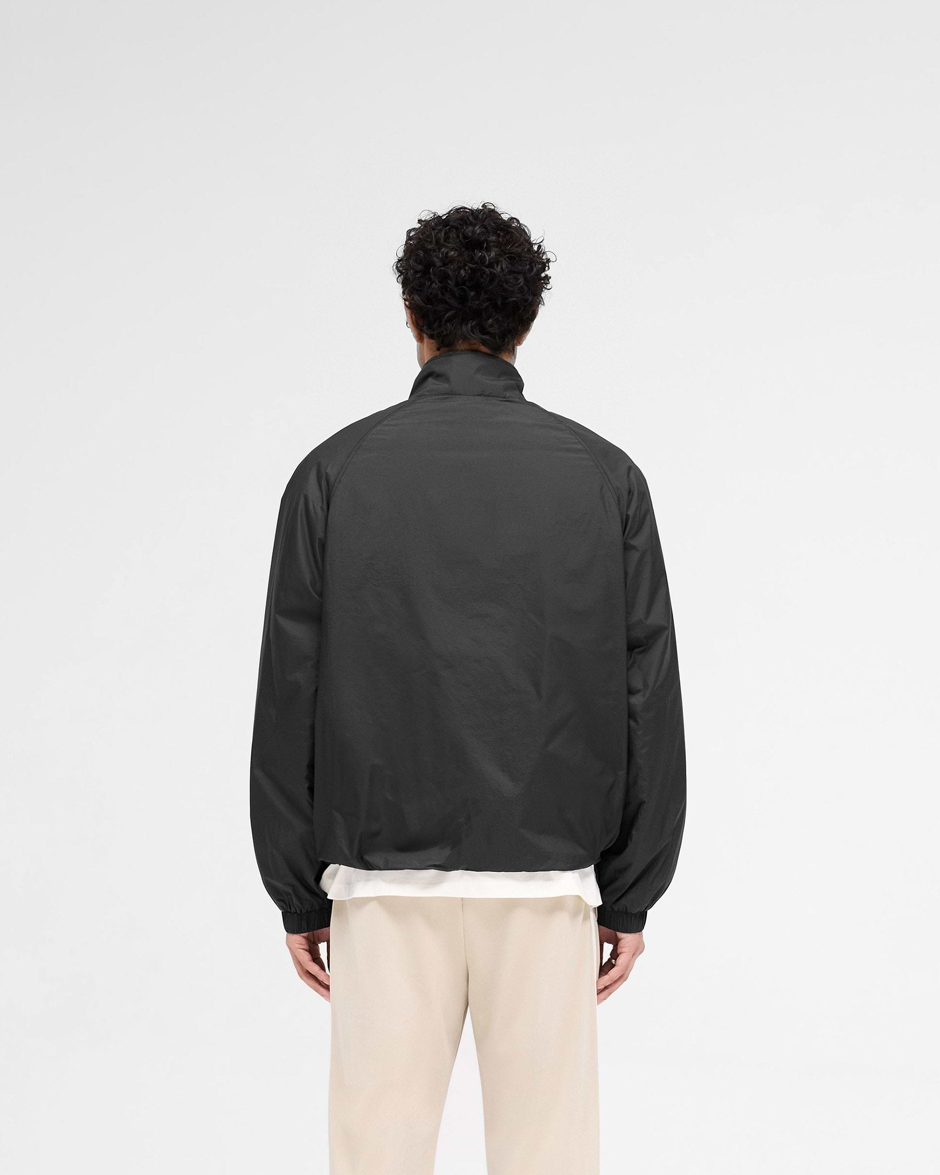 Man wearing a black jacket on a plain white background | Funnel Neck Jacket in Black | Jacket with funnel neck and raglan sleeves | SS25 Outerwear | Represent Clo