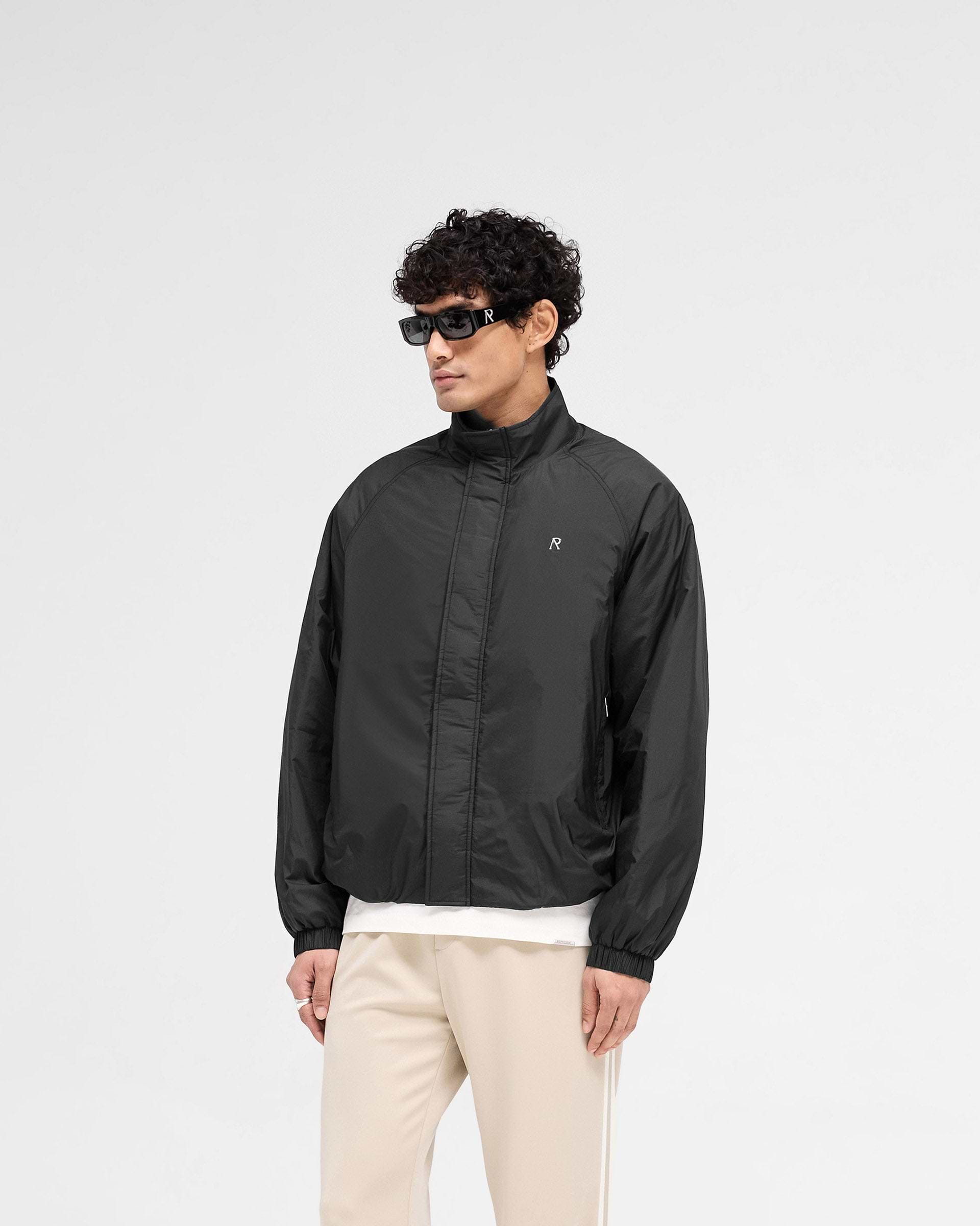 Back product image of a mens black jacket on a plain white background | Funnel Neck Jacket in Black | Nylon jacket with funnel neck and raglan sleeves | SS25 Outerwear | Represent Clo