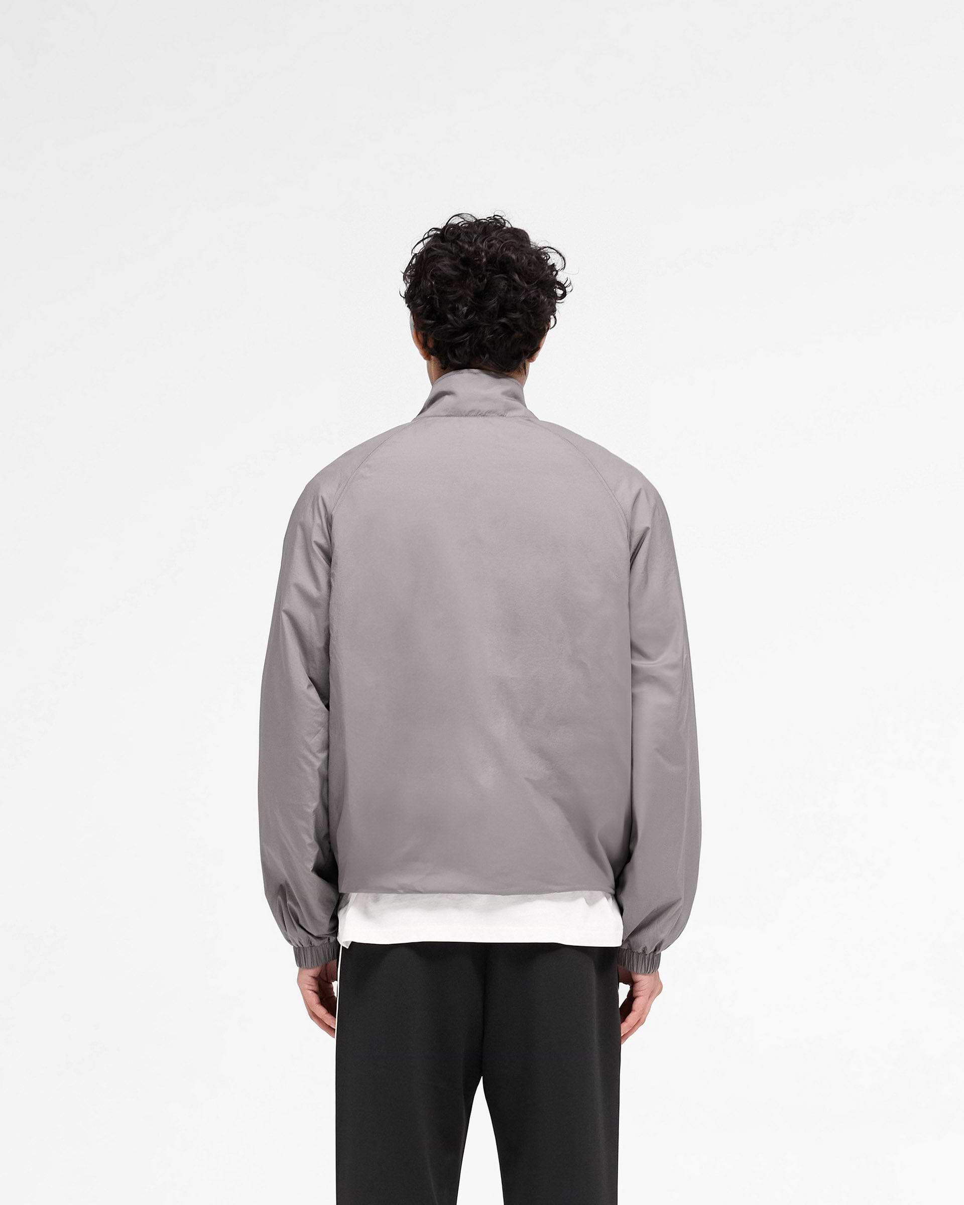 Man wearing a stone jacket on a plain white background | Funnel Neck Jacket in Stone | Outerwear with funnel neck and raglan sleeves | SS25 Outerwear | Represent Clo