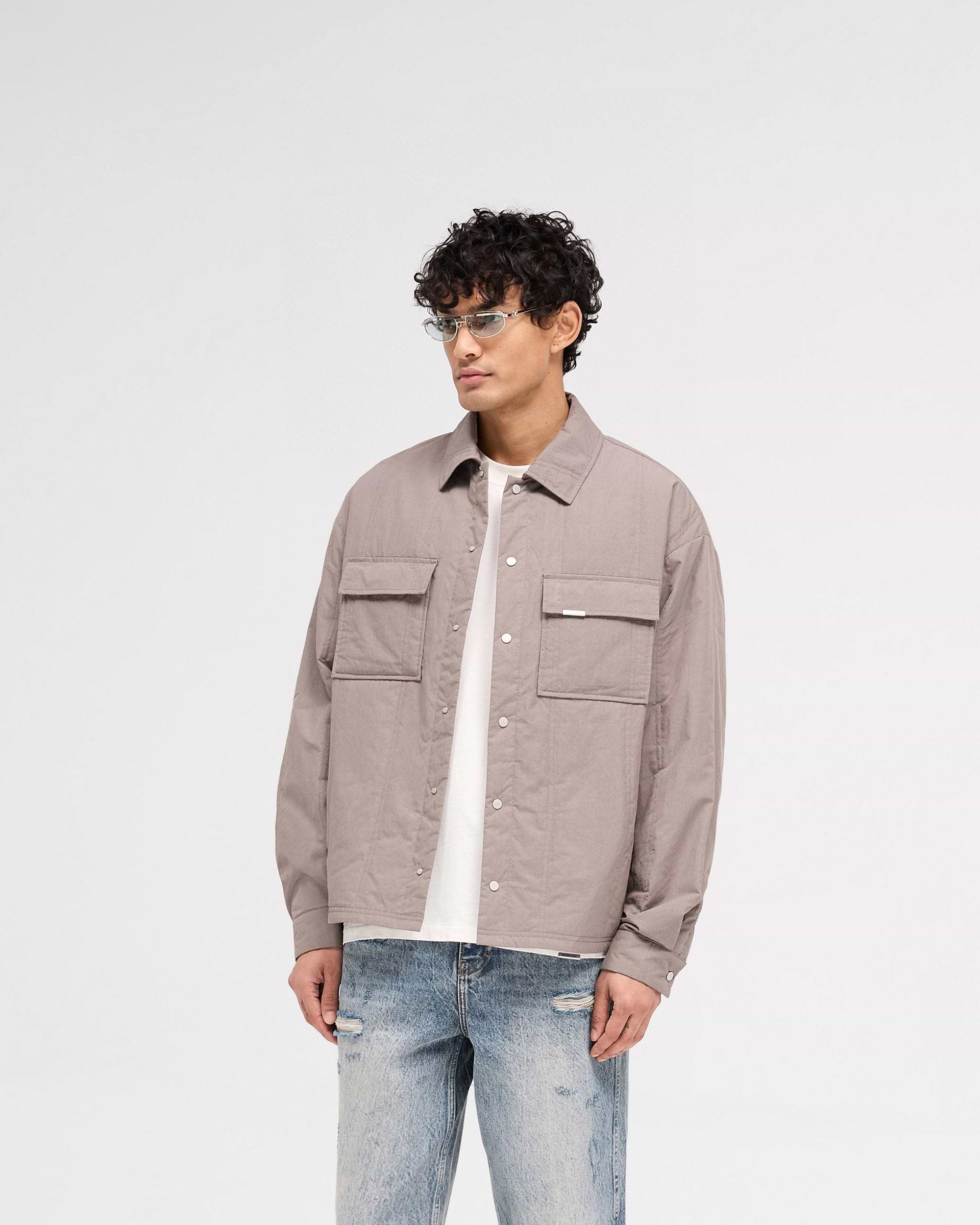 Back product image of a mens grey quilted overshirt on a plain white background | Quilted Overshirt in Mid Grey | Overshirt with twin needle vertical quilting and light wadding | SS25 Shirts | Represent Clo