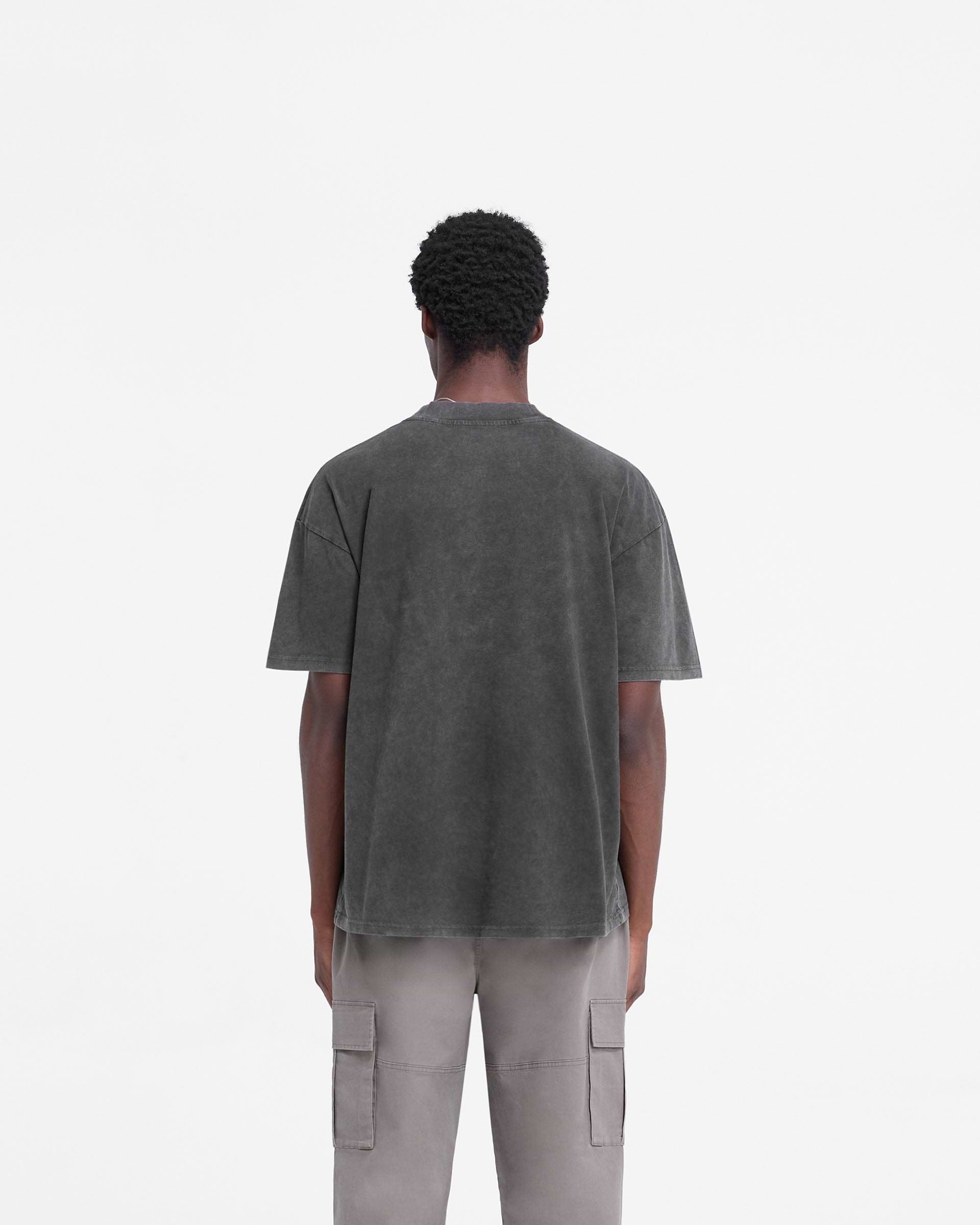 Man wearing a vintage black t-shirt on a plain white background | Rep Applique T-Shirt in Vintage Black | Slightly oversized t-shirt with distressed applique Rep logo | FW24 T-Shirts | Represent Clo