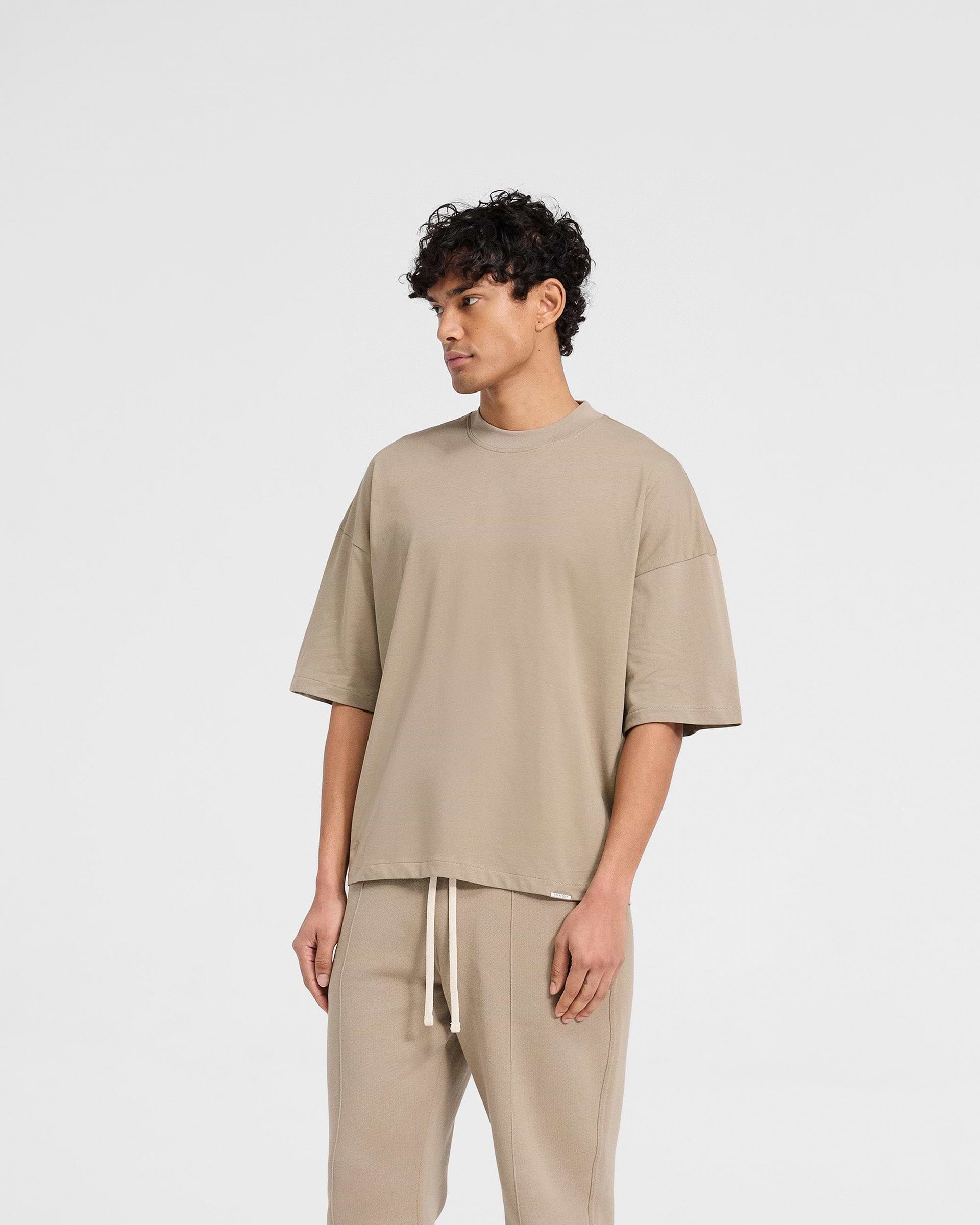 Back product image of a mens beige t-shirt on a plain white background | Initial Boxy T-Shirt in Dune | Boxy cropped t-shirt with ribbed collar | Initial T-Shirts | Represent Clo