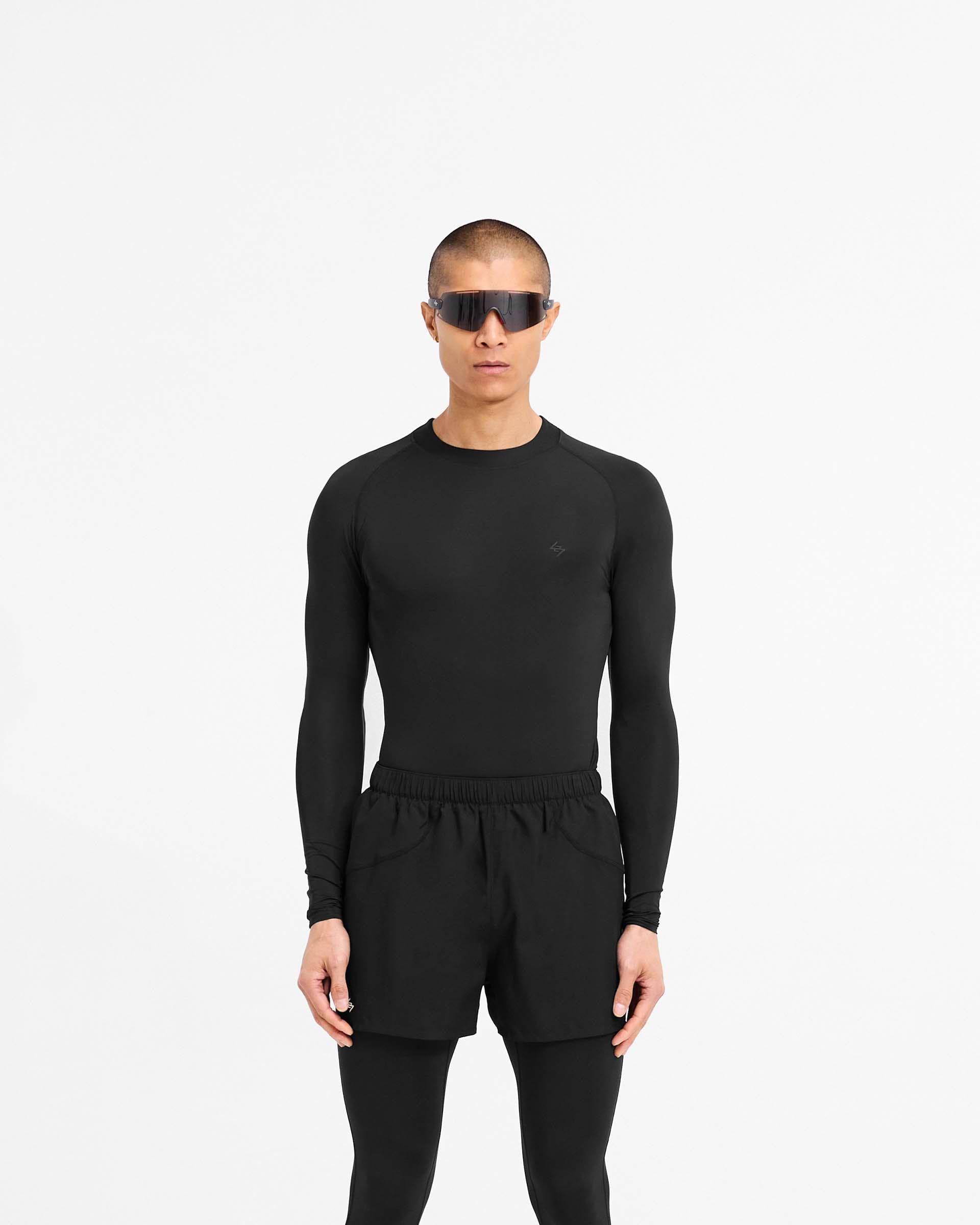 Man wearing a black long sleeve t-shirt on a plain white background | 247 Compound Long Sleeve T-Shirt in Black | Performance t-shirt with raglan sleeves and flatlock stitching | 247 T-Shirts | Represent Clo