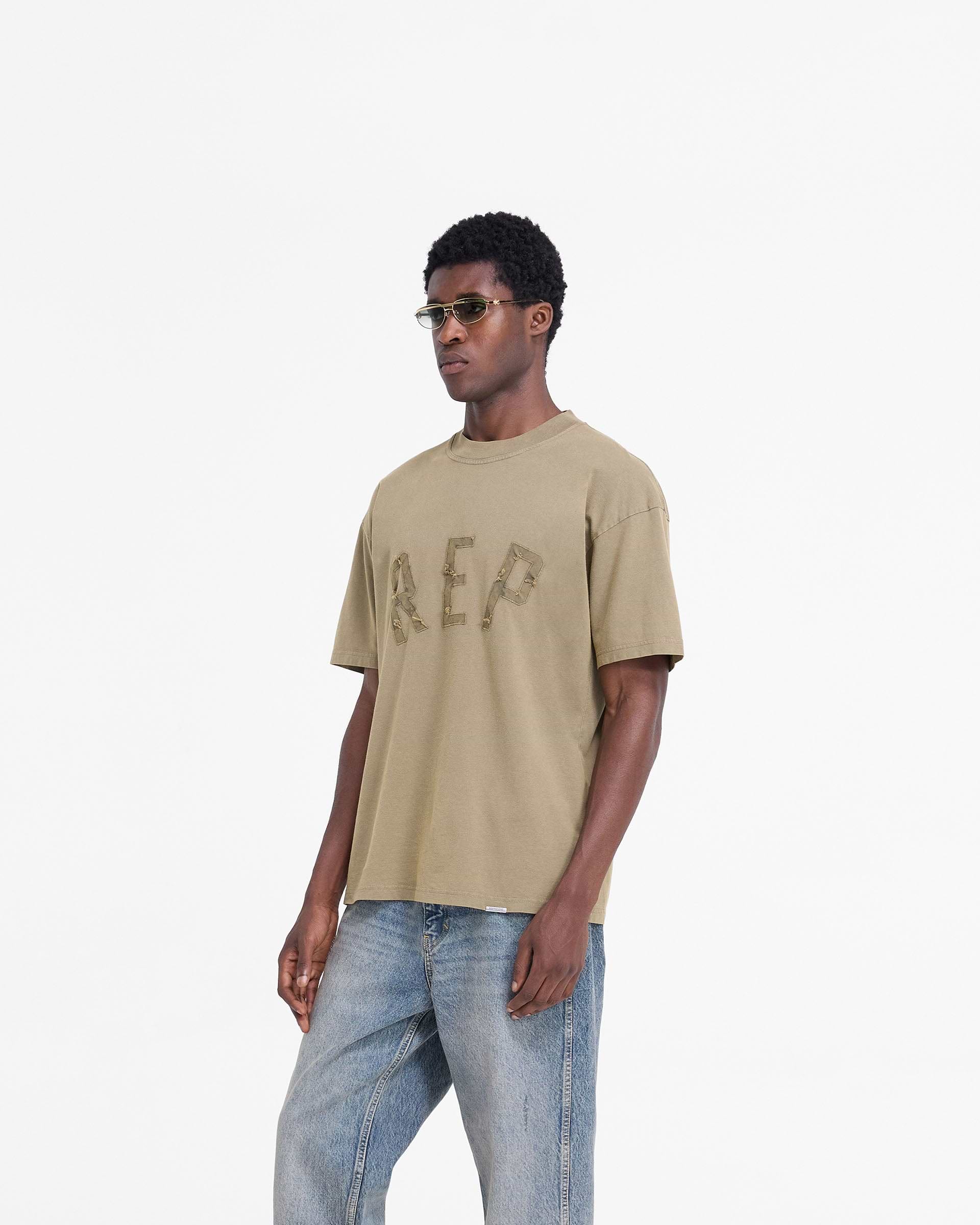 Back product image of a mens fawn t-shirt on a plain white background | Rep Applique T-Shirt in Fawn | Slightly oversized t-shirt with sun fade wash | FW24 T-Shirts | Represent Clo
