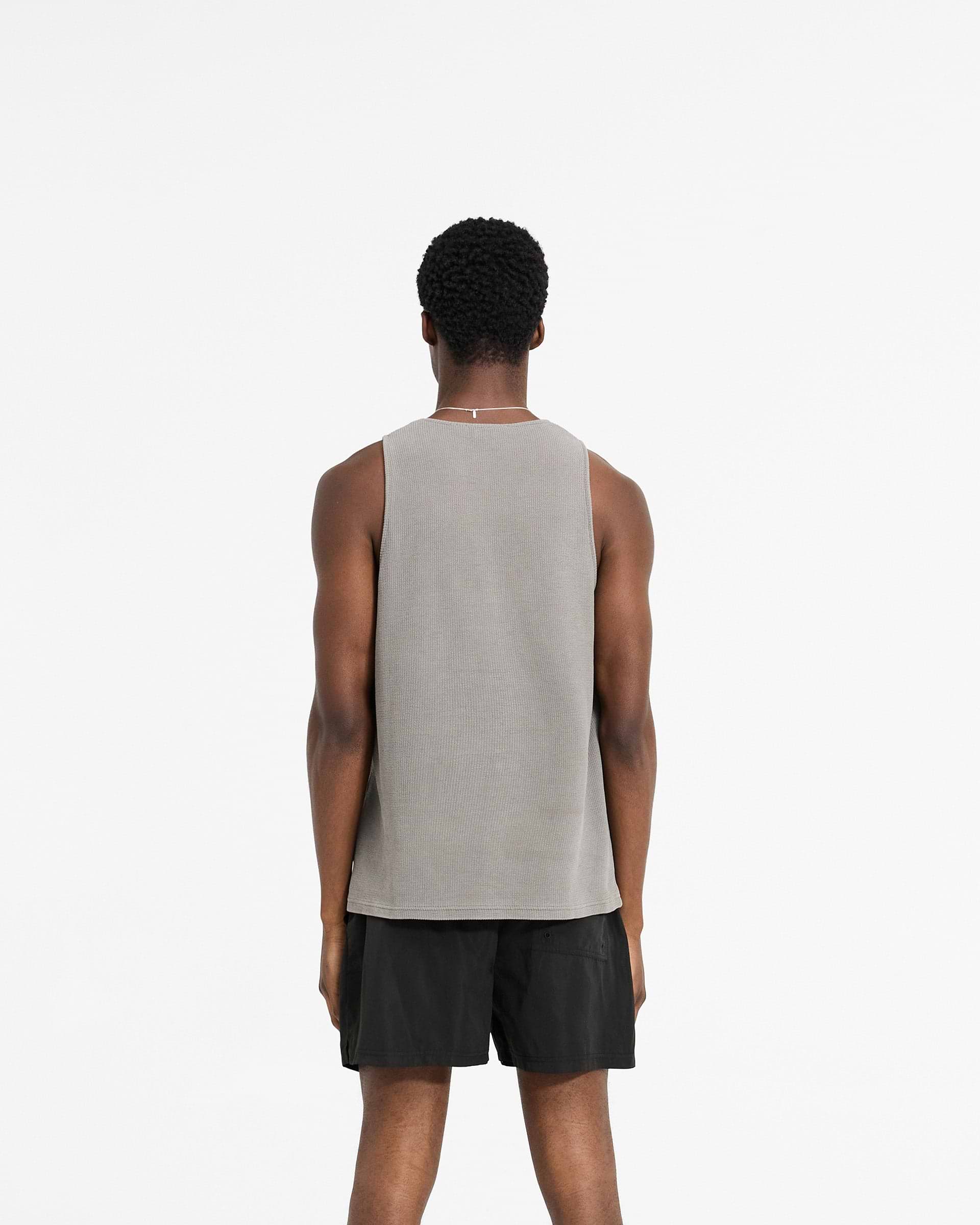 Man wearing a grey waffle vest on a plain white background | Waffle Vest in Ultimate Grey | Regular fit vest with mineral wash and embroidery | SC24 T-Shirts | Represent Clo