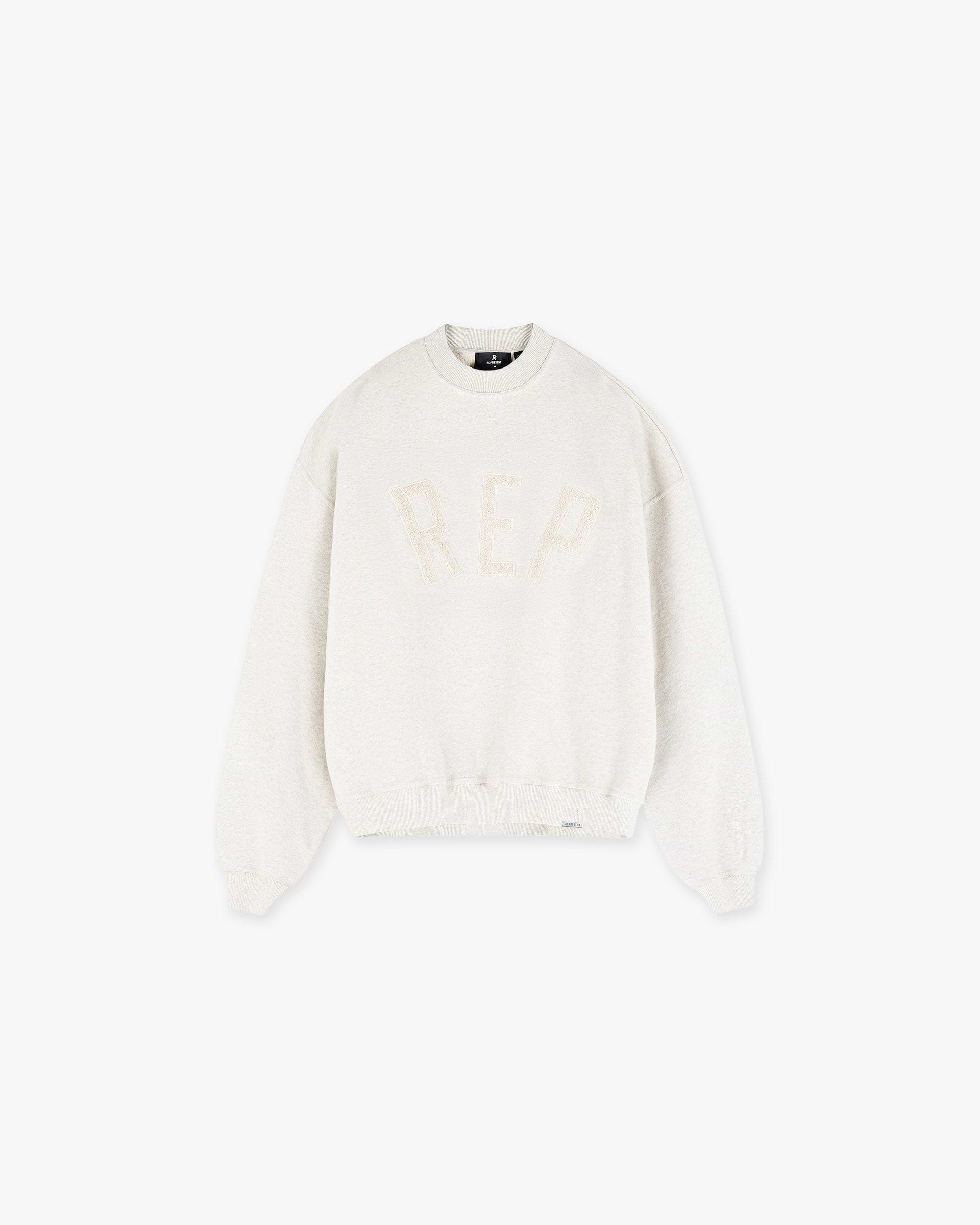 Front product image of a mens cream sweater on a plain white background | Rep Applique Sweater in Cream Marl | Applique detailed sweater | SS25 Sweaters | Represent Clo