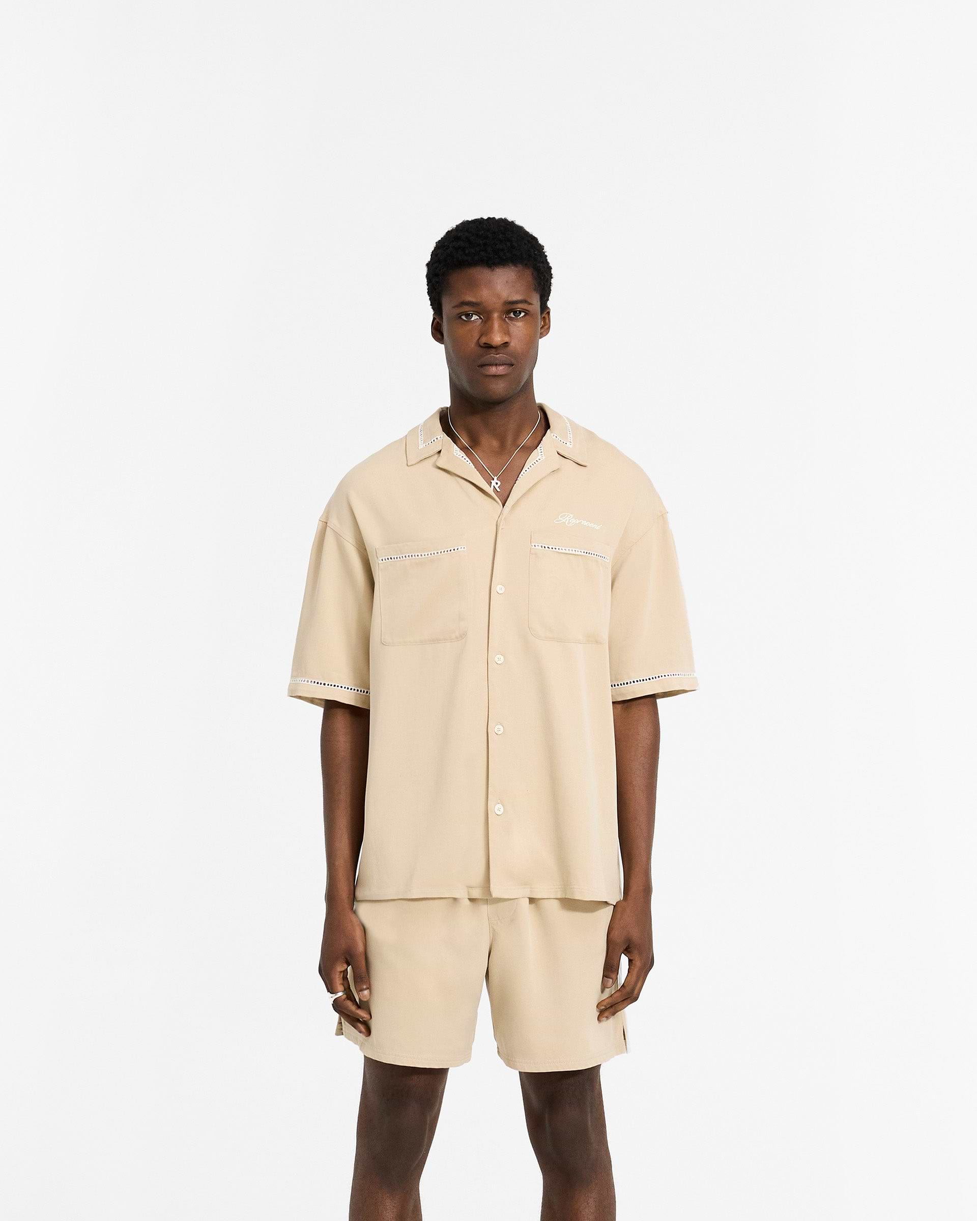 Man wearing a latte brown drapey shirt on a plain white background | Resort Shirt in Latte | Shirt with revere collar and chest pockets | SC24 Shirts | Represent Clo