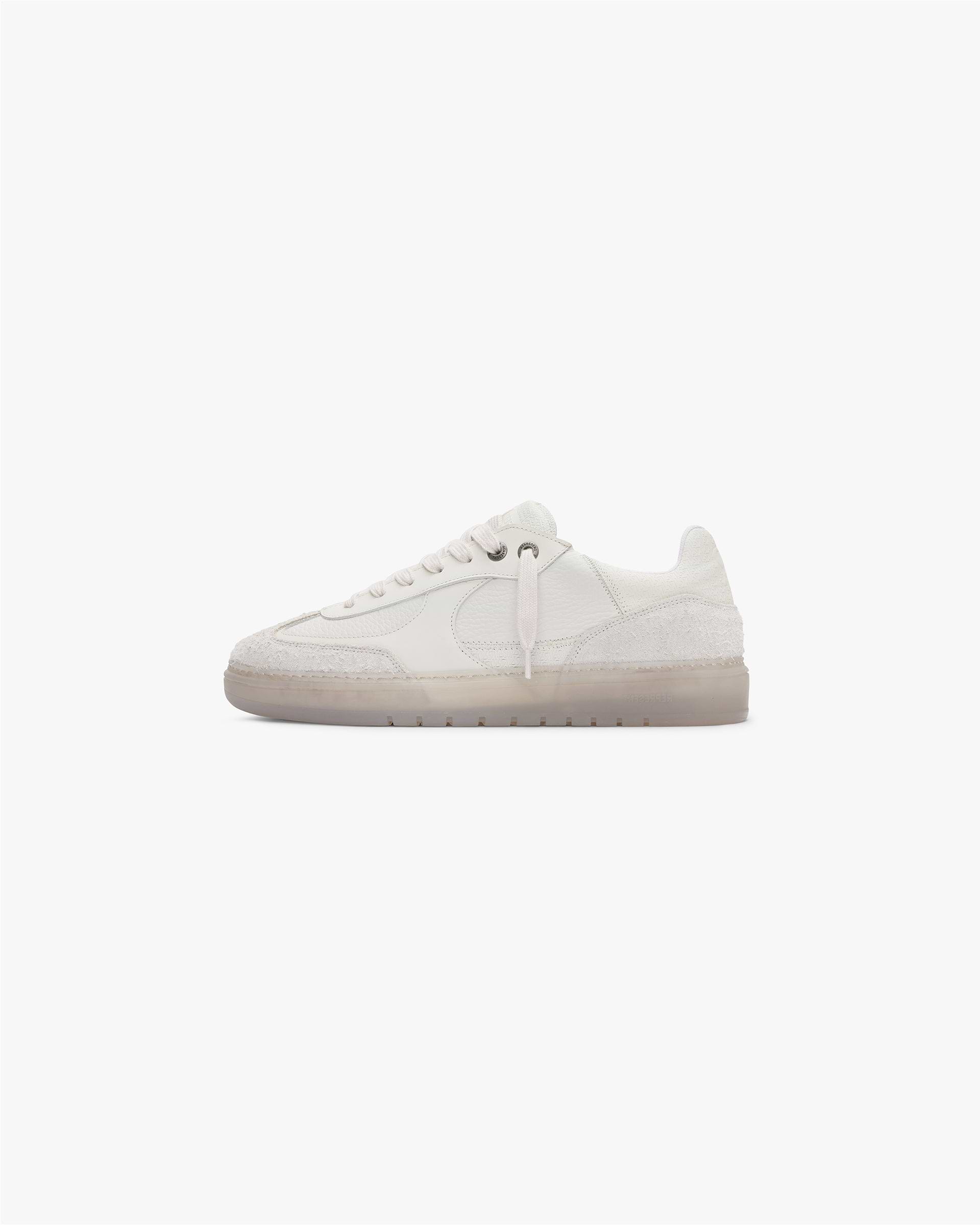 Close-up of mens white sneaker on a plain white background | Virtus in Vintage White | Low profile minimalist sneaker with leather and suede upper | FW23 Footwear | Represent Clo