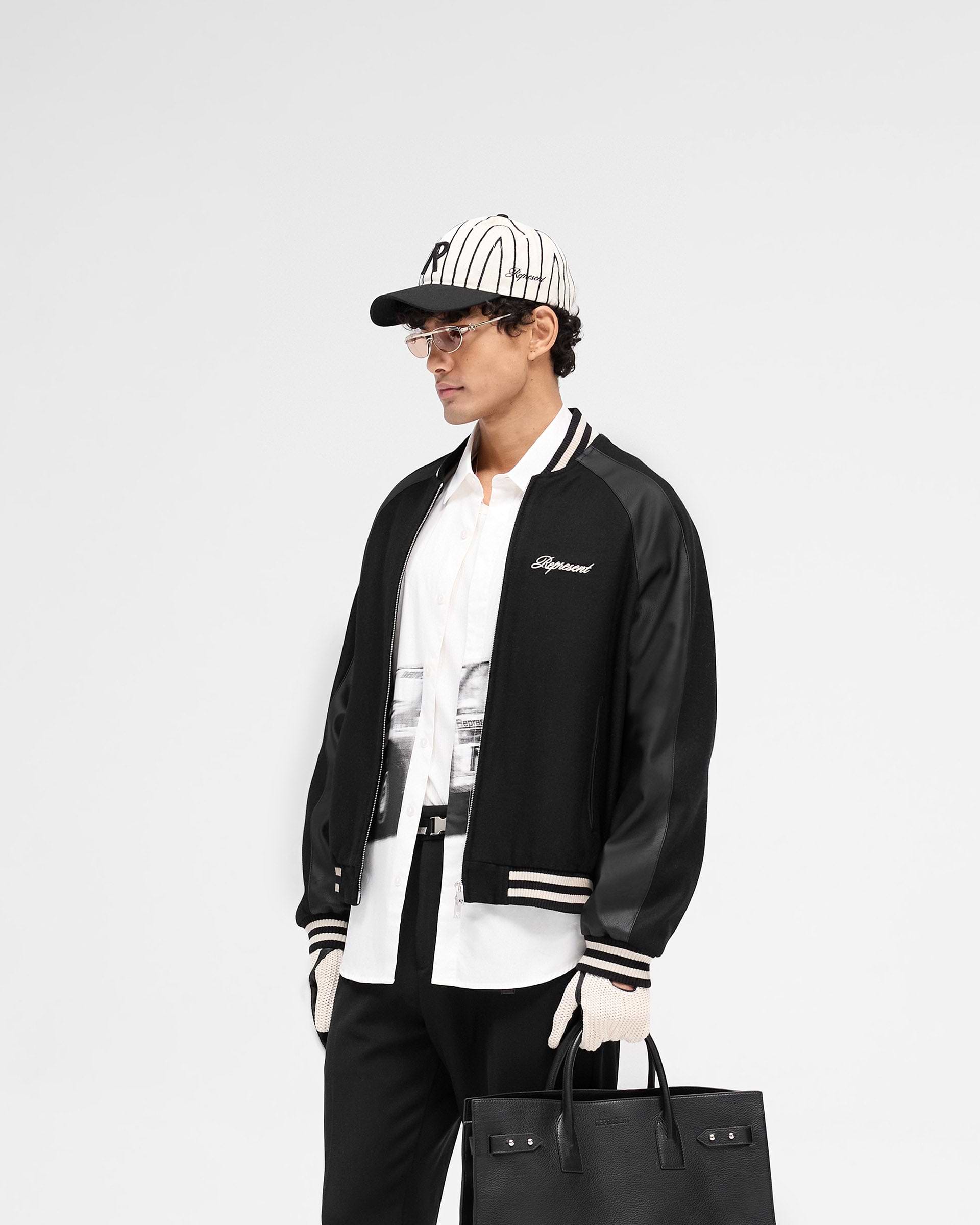Back product image of a mens black jacket on a plain white background | Raglan Varsity Jacket in Black | Jacket with raglan PU sleeves and zip pockets | SS25 Outerwear | Represent Clo