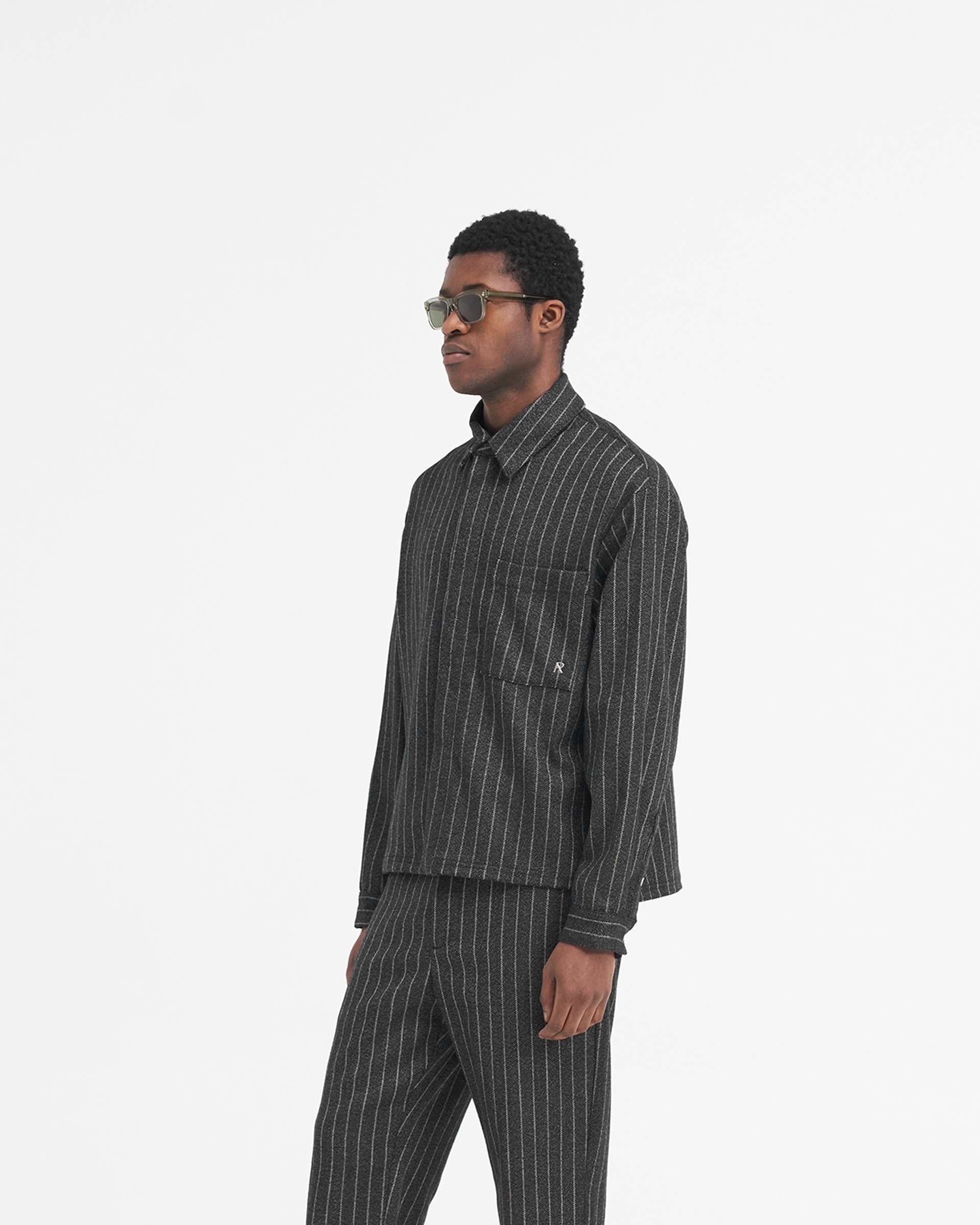 Back product image of a mens black pinstripe cropped shirt on a plain white background | Cropped Dress Shirt in Black Pinstripe | Luxury shirt with soft hand feel and stepped hem | SS24 Shirts | Represent Clo