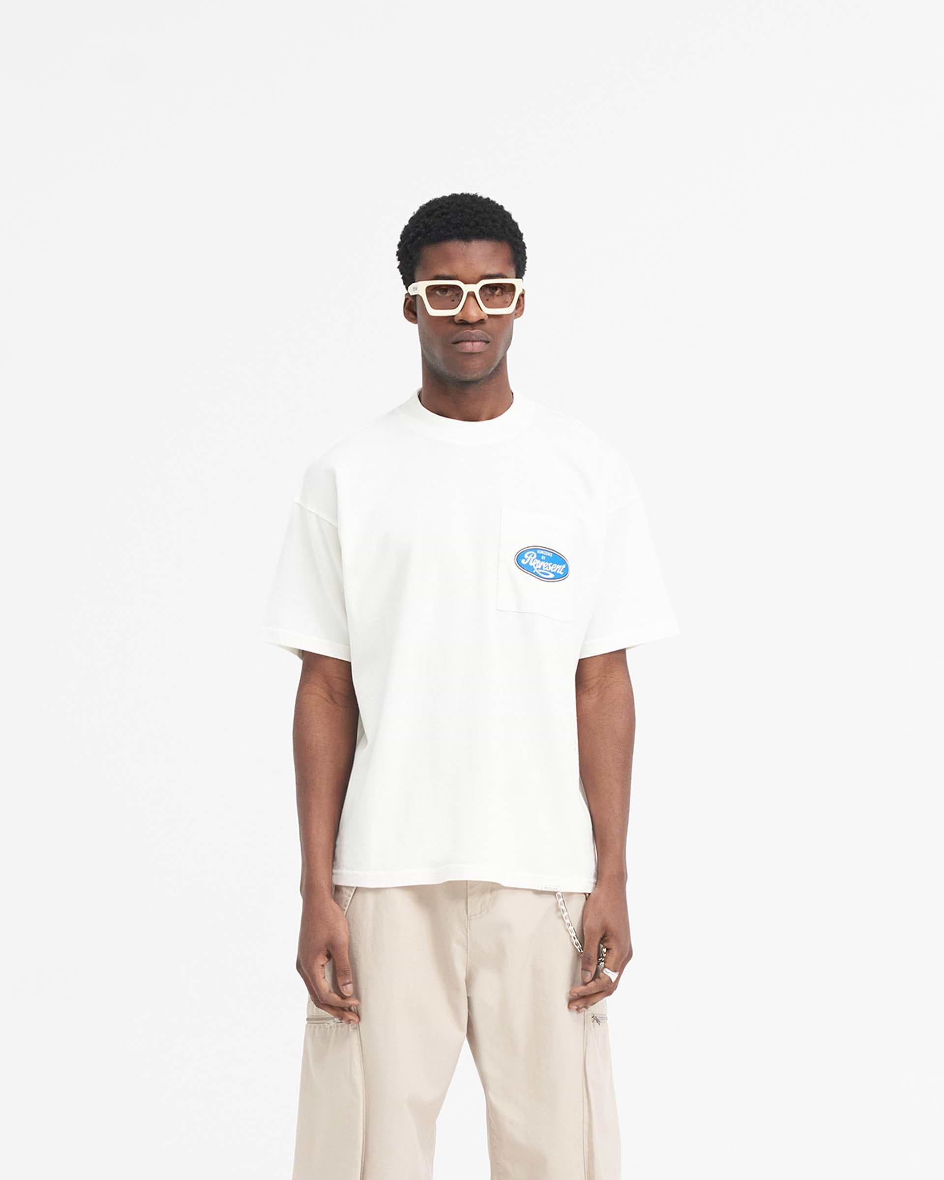 Man wearing an oversized white t-shirt on a plain white background | Classic Parts T-Shirt in Flat White | T-shirt with Horizons motorsport graphic | SS24 T-Shirts | Represent Clo