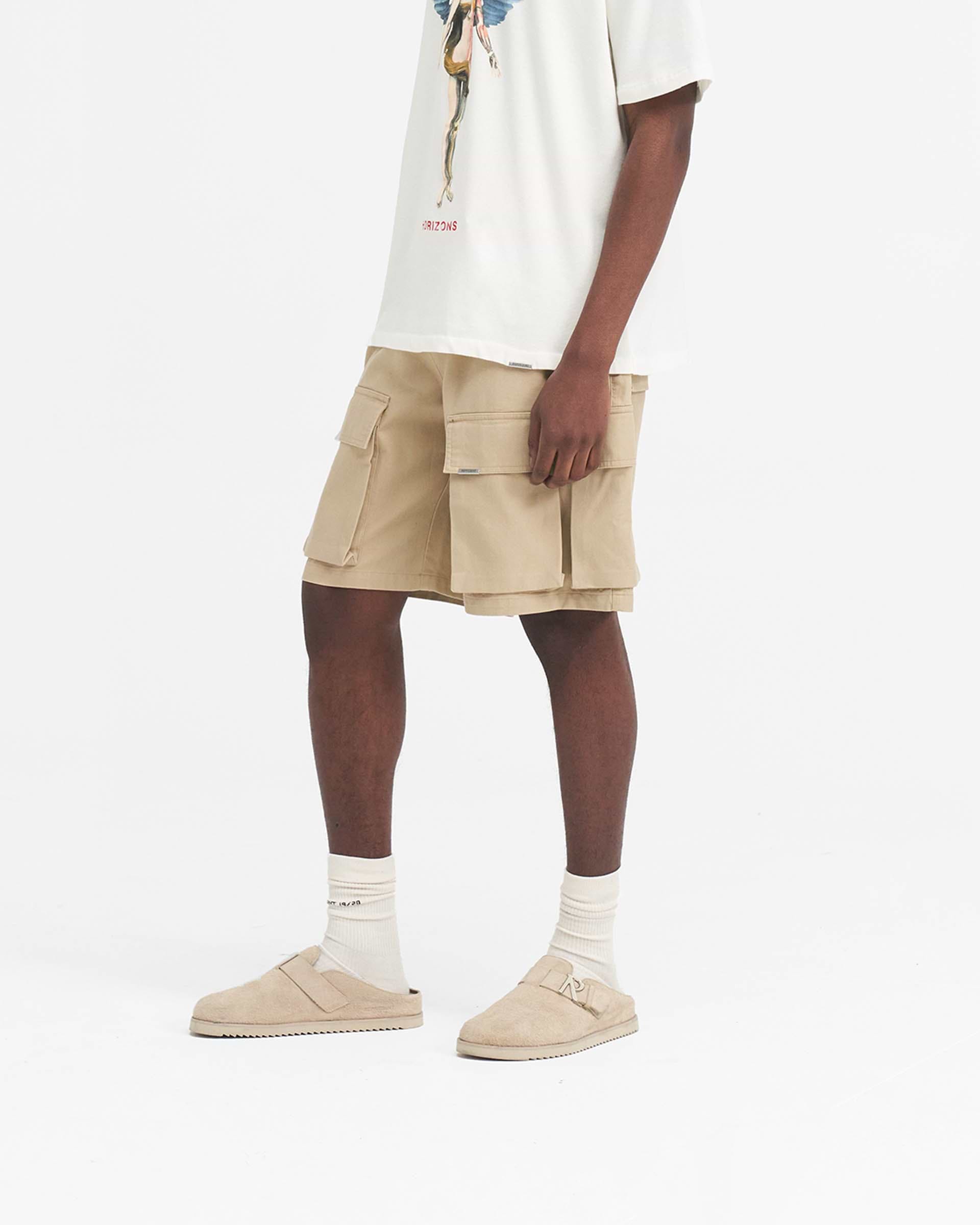 Back product image of a mens beige cotton cargo short on a plain white background | Baggy Cotton Cargo Short in Sandstone | Cargo shorts with baggy fit and oversized 3D pockets | SS24 Shorts | Represent Clo