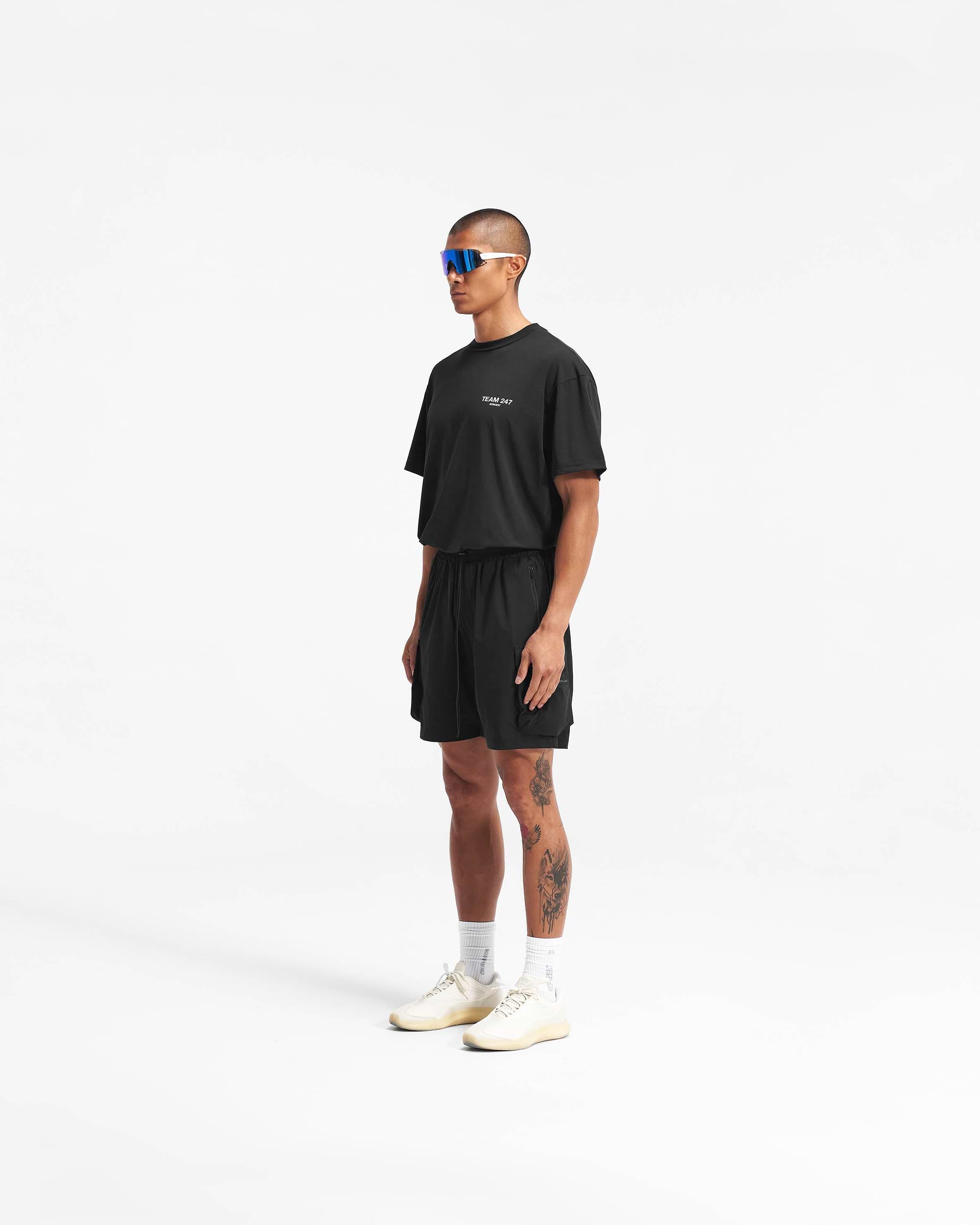 Back product image of mens black shorts on a plain white background | 247 Shorts in Black | Combat shorts with cargo leg pockets and elasticated drawstring waist | 247 Shorts | Represent Clo