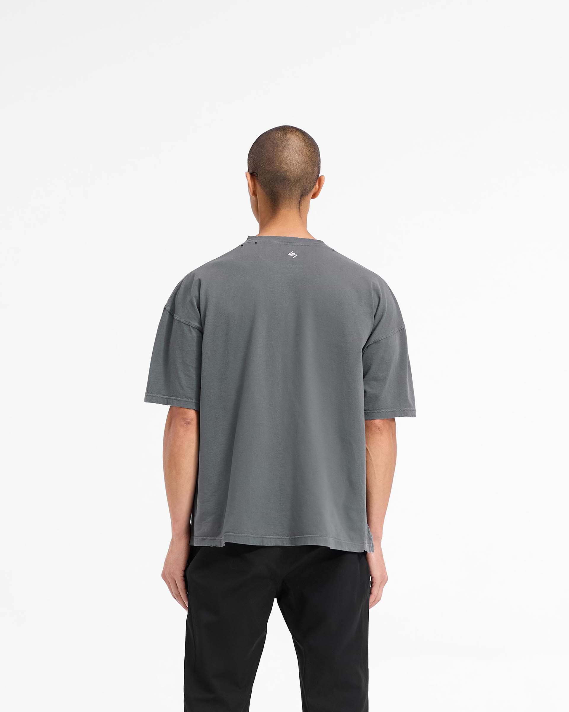 Man wearing a slightly oversized black t-shirt on a plain white background | 247 On A Mission Oversized T-Shirt in Aged Black | Lightweight jersey cotton t-shirt with embroidery and distressing details | 247 T-Shirts | Represent Clo
