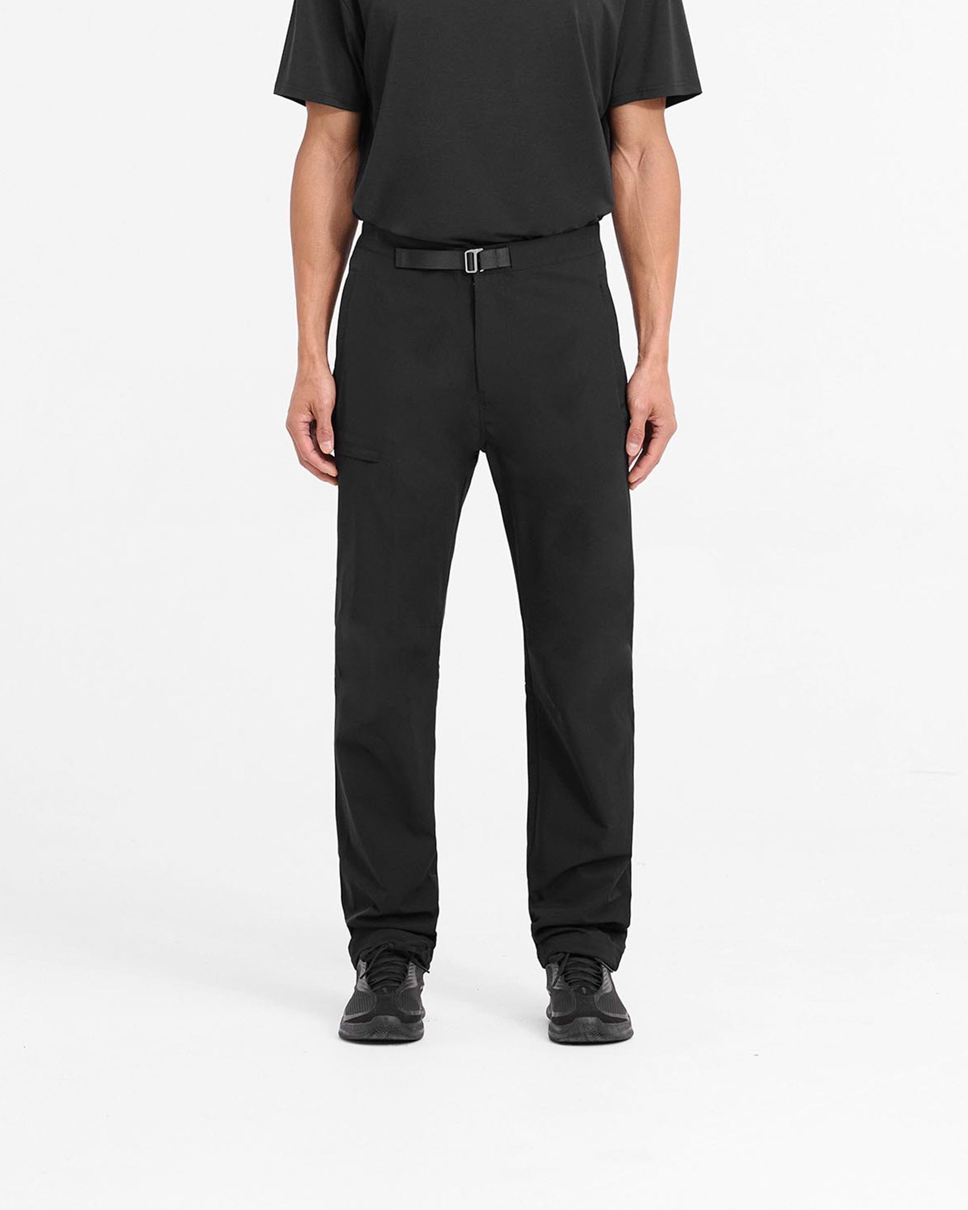 Man wearing black pants on a plain white background | 247 Mission Pant in Black | Stretch nylon pants with zip pockets and built-in belt | 247 Pants | Represent Clo