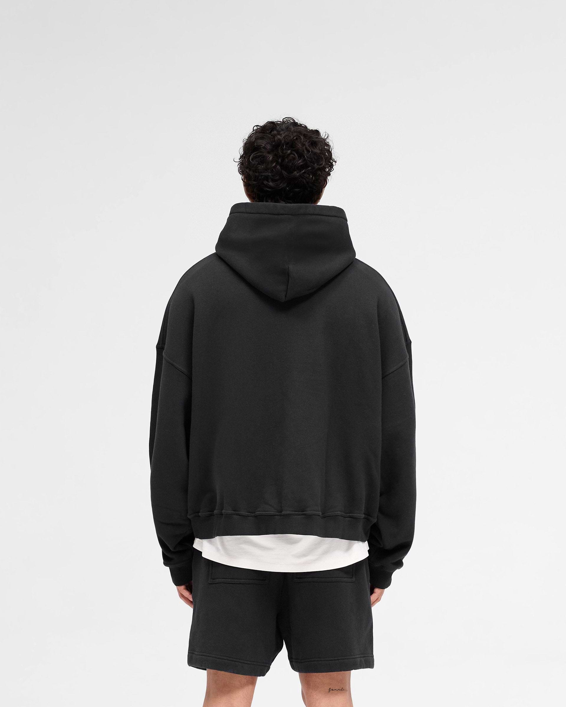 Man wearing an off black hoodie on a plain white background | Rep Applique Hoodie in Off Black | Boxy fit hoodie with textured Rep applique | SS25 Hoodies | Represent Clo