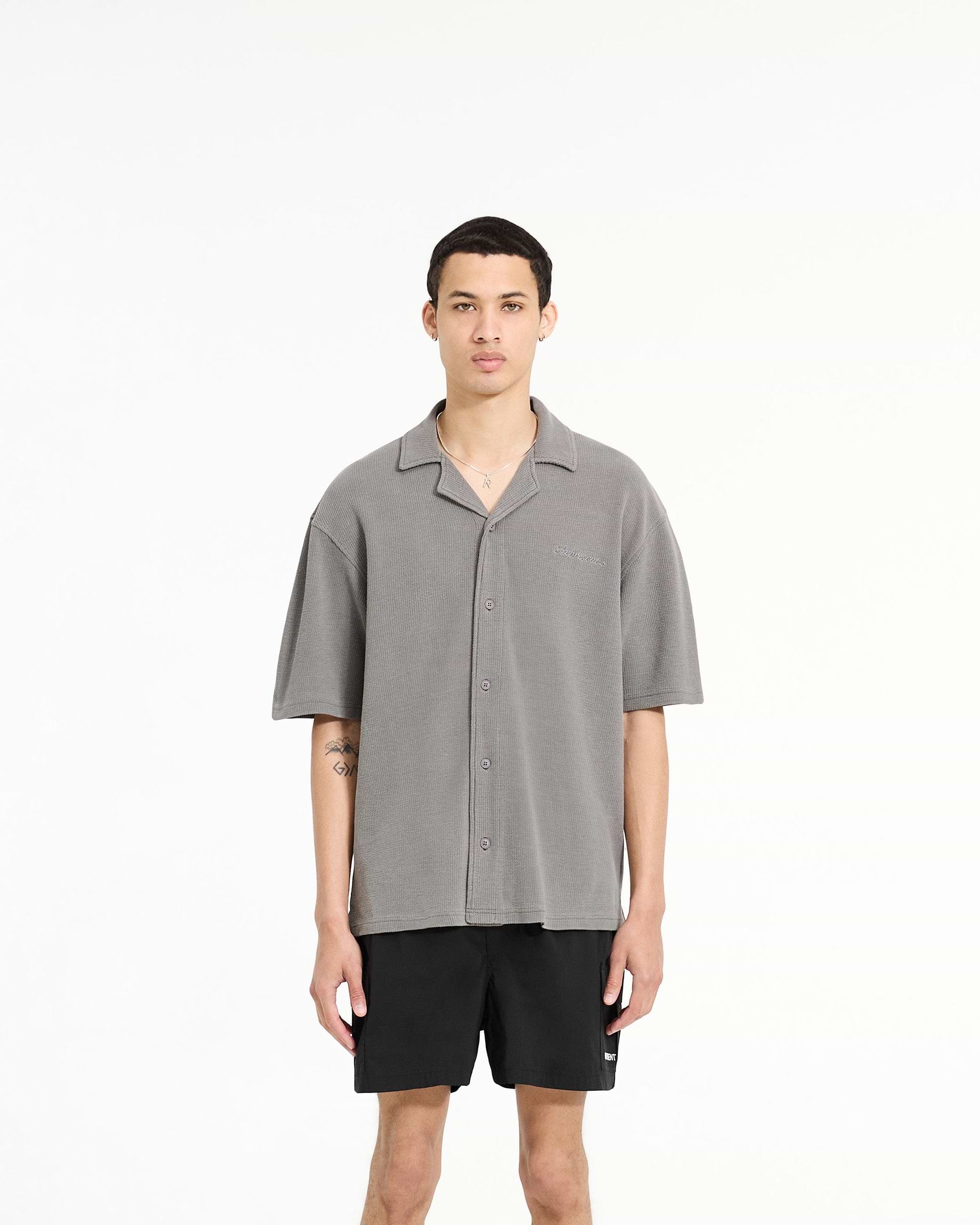 Man wearing a grey waffle shirt on a plain white background | Waffle Shirt in Ultimate Grey | Drapey shirt with revere collar and side split hem | SC24 Shirts | Represent Clo