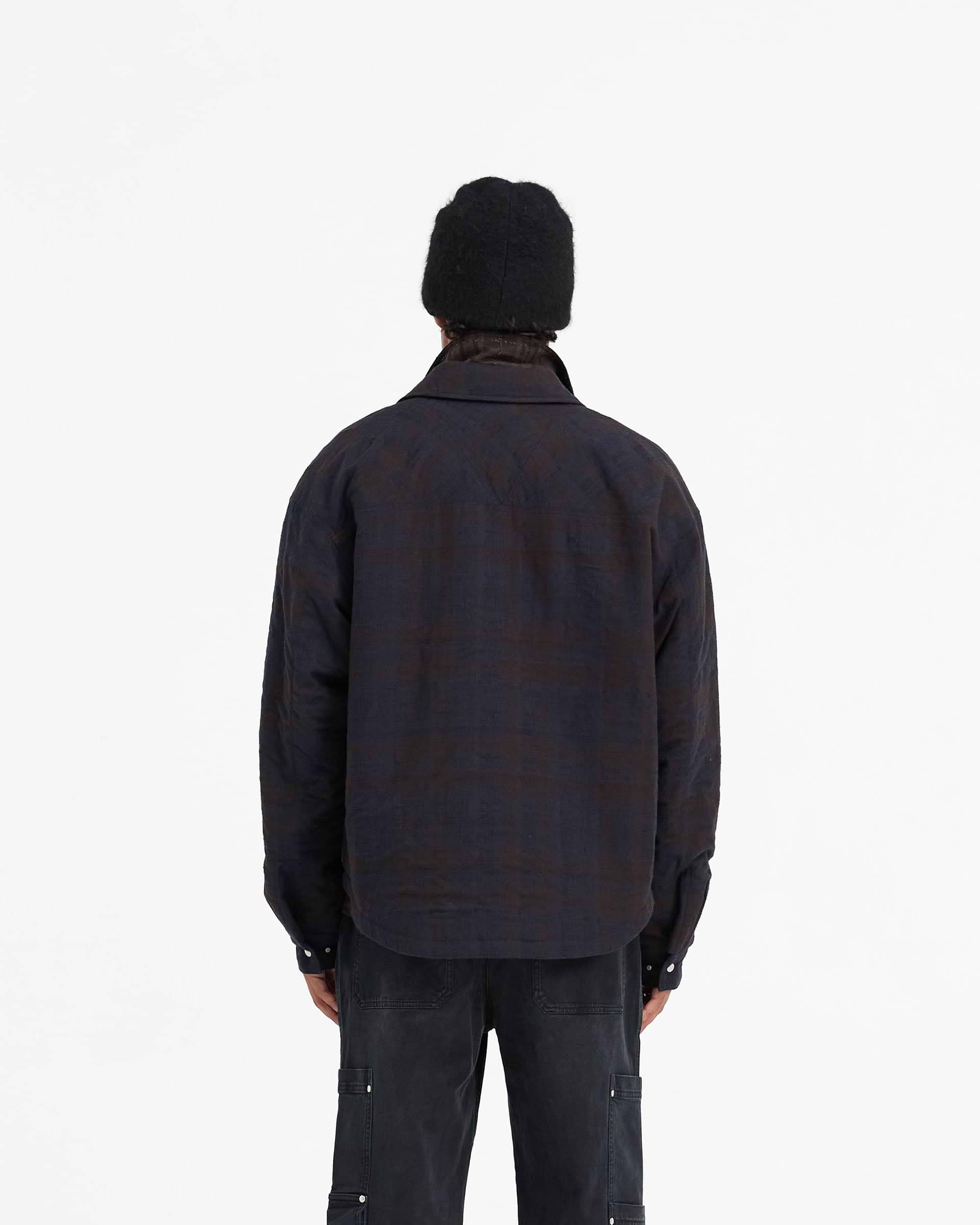 Man wearing a navy overshirt on a plain white background | Wadded Zip Overshirt in Midnight Navy | Wadded overshirt with zip closure and pockets | FW24 Shirts | Represent Clo