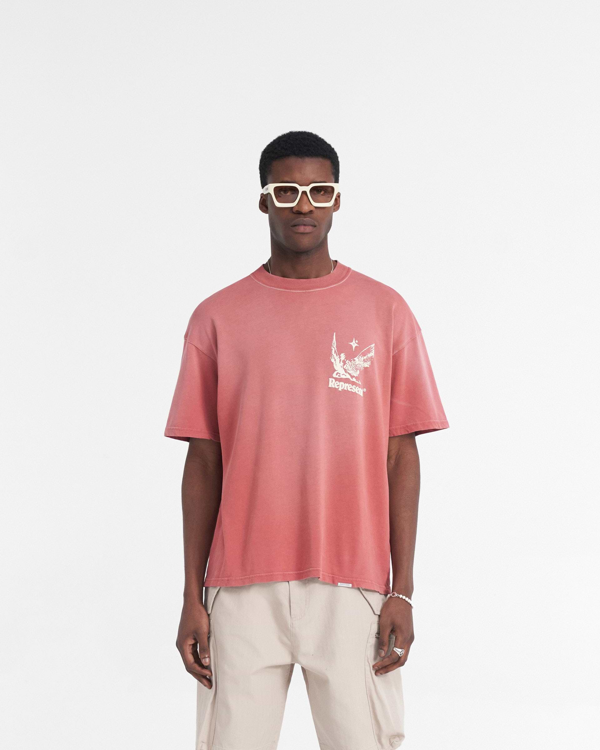 Man wearing an oversized orange t-shirt on a plain white background | Spirits Of Summer T-Shirt in Sunrise | Oversized t-shirt with puff print graphic | SS24 T-Shirts | Represent Clo