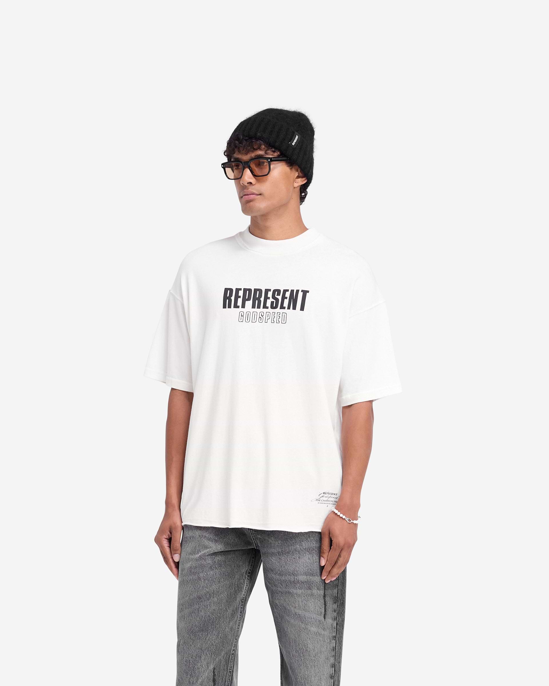 Man wearing a white t-shirt on a plain white background | Godspeed T-Shirt in Flat White | Oversized t-shirt with raw hem and cracked graphics | FW24 T-Shirts | Represent Clo