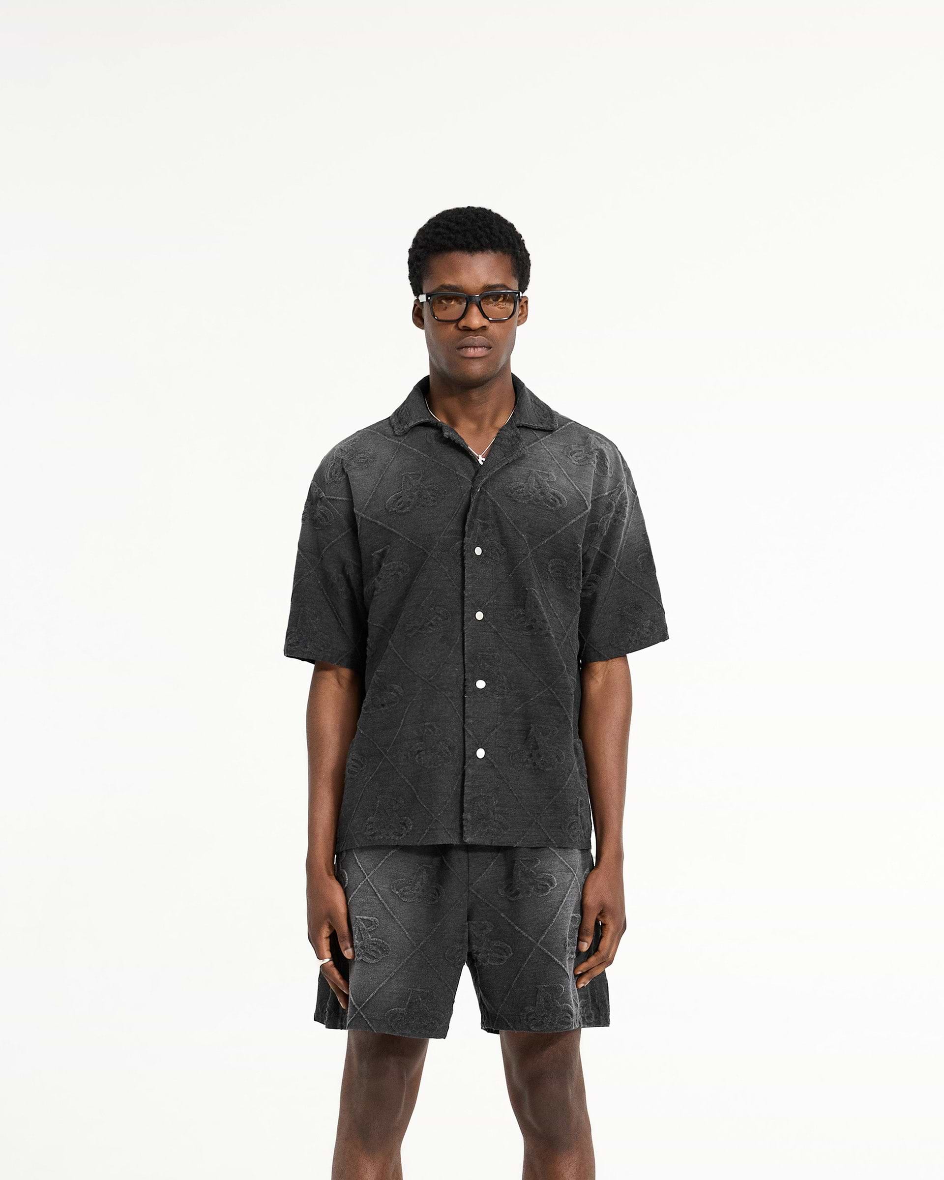 Man wearing a black towelling shirt on a plain white background | Towelling Shirt in Jet Black | Oversized fit shirt with popper fastenings | SC24 Shirts | Represent Clo