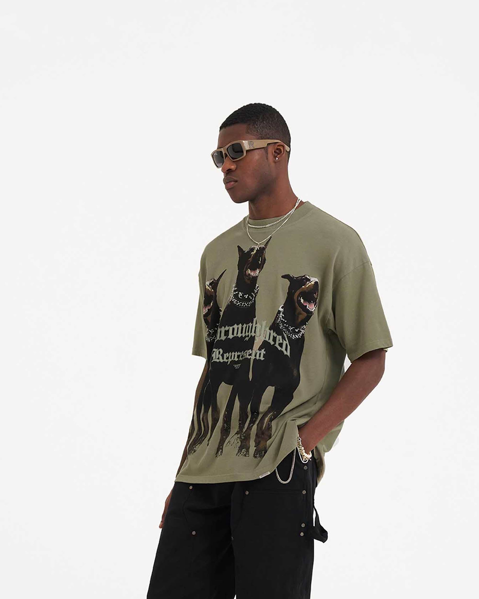 Man wearing a khaki t-shirt on a plain white background | Thoroughbred T-Shirt in Khaki | Short sleeve t-shirt with Thoroughbred graphic | SS23 T-Shirts | Represent Clo