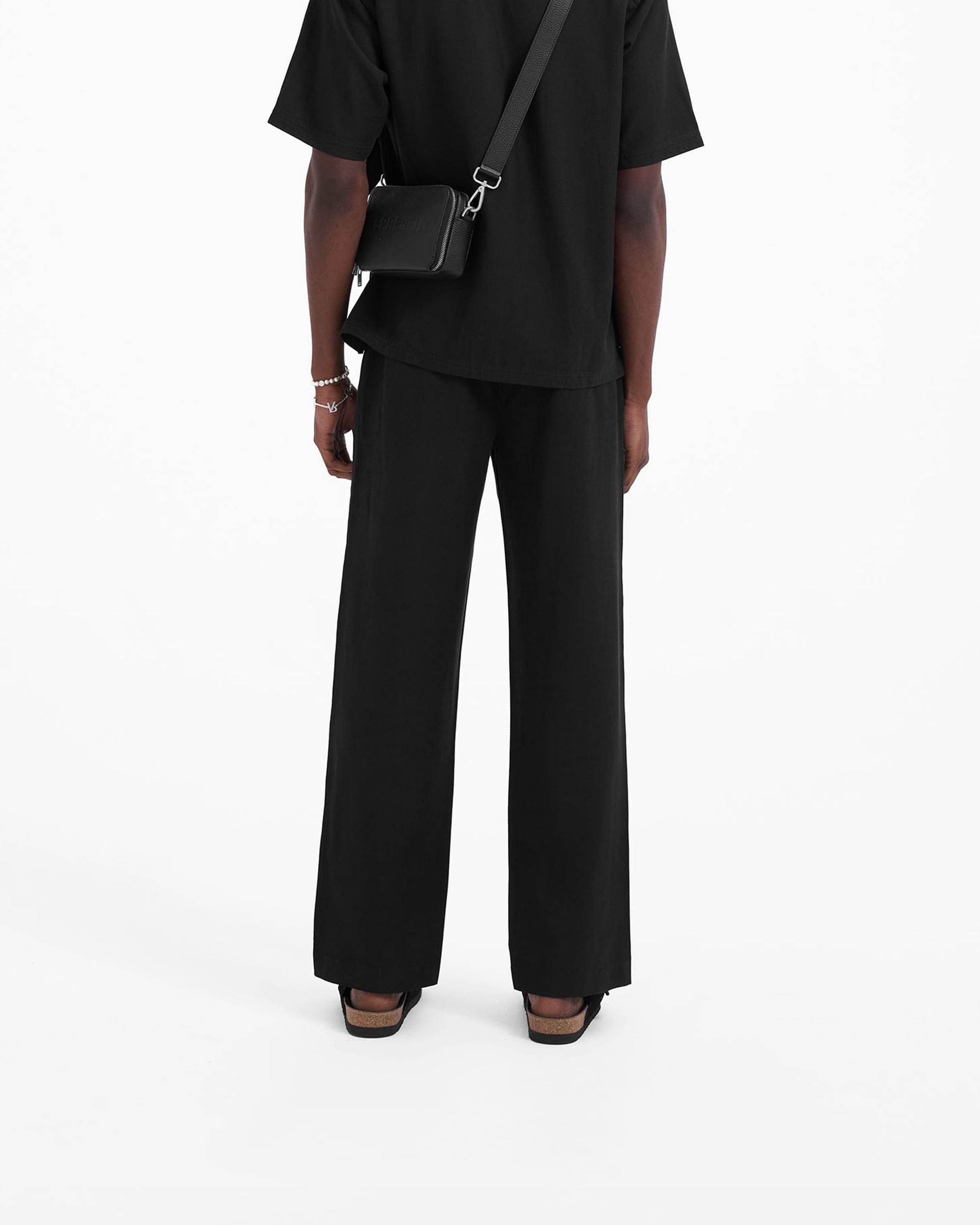 Man wearing black pants on a plain white background | Yacht Pant in Black | Baggy fit pants with hybrid elasticated waistband | SC23 Pants | Represent Clo