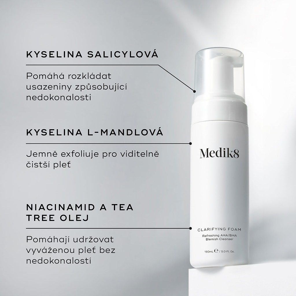 Pumpičková lahvička Medik8 Clarifying Foam stojí na bílém podstavci na čistém šedém pozadí. Text vyzdvihuje klíčové složky:Kyselina salicylová – k rozkládání usazenin způsobujících nedokonalosti.
Kyselina L-mandlová – pro jemnou exfoliaci a projasněnou pleť.
Niacinamid a tea tree olej – pomáhají udržovat pleť vyváženou a bez nedokonalostí.