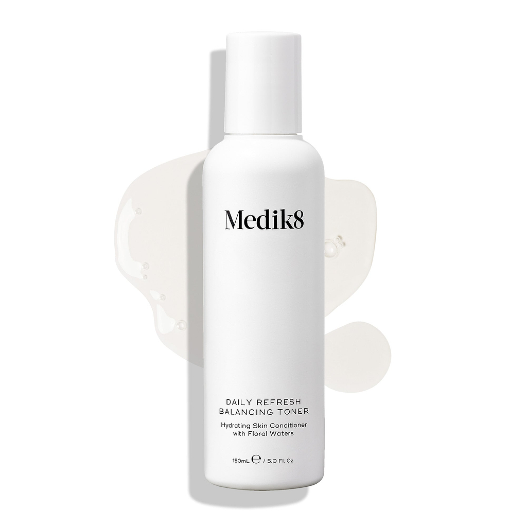 Lahvička Medik8 Daily Refresh Balancing Toner stojí na bílém pozadí s rozlitou čirou tekutinou.

Text jej označuje jako hydratační pleťový kondicionér s květinovými vodami ve velikosti 150 ml.