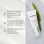 Tuba Advanced Day Eye Protect leží na mramorovém povrchu vedle zeleného listu kapradiny. Text zdůrazňuje její ochranu SPF 30, prevenci viditelných známek stárnutí a schopnost rozjasnit a redukovat otoky v očním okolí.