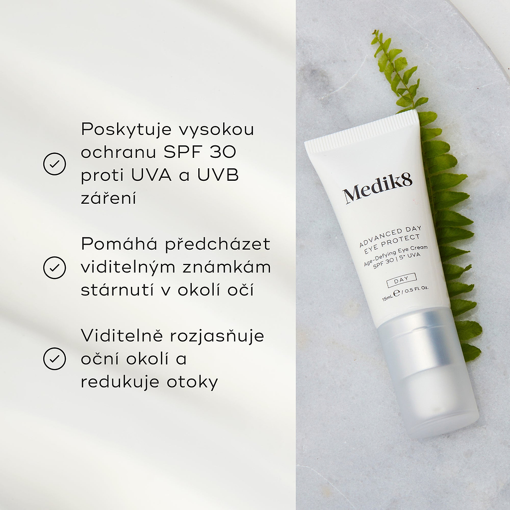 Tuba Advanced Day Eye Protect leží na mramorovém povrchu vedle zeleného listu kapradiny. Text zdůrazňuje její ochranu SPF 30, prevenci viditelných známek stárnutí a schopnost rozjasnit a redukovat otoky v očním okolí.