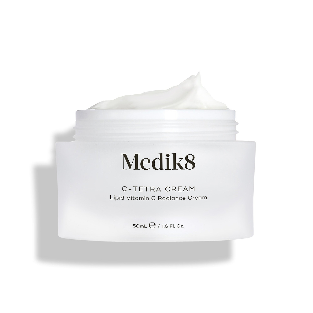 Medik8 C-Tetra Cream Glascreme geöffnet auf sauberem weißen Hintergrund mit weichen Schatten. Das weiße, mattierte Glas zeigt das Medik8-Logo und ist als C-TETRA CREAM Lipid Vitamin C Radiance Cream in 50 mL Größe gekennzeichnet. Eine dicke weiße Cremeschnecke auf dem Glas zeigt die feuchtigkeitsspendende Textur.