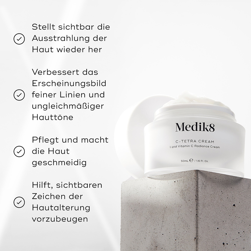 Medik8 C-Tetra Cream-Glas auf einem grauen Steinblock vor weißem Hintergrund mit sanften Lichtstrahlen dargestellt. Das Bild zeigt vier Häkchen-Behauptungen: Sichtbare Wiederherstellung der Hautstrahlung, Verbessert das Erscheinungsbild von feinen Linien & ungleichmäßigem Hautton, Pflegt & macht die Haut weich, Hilft, sichtbare Zeichen der Hautalterung zu verhindern