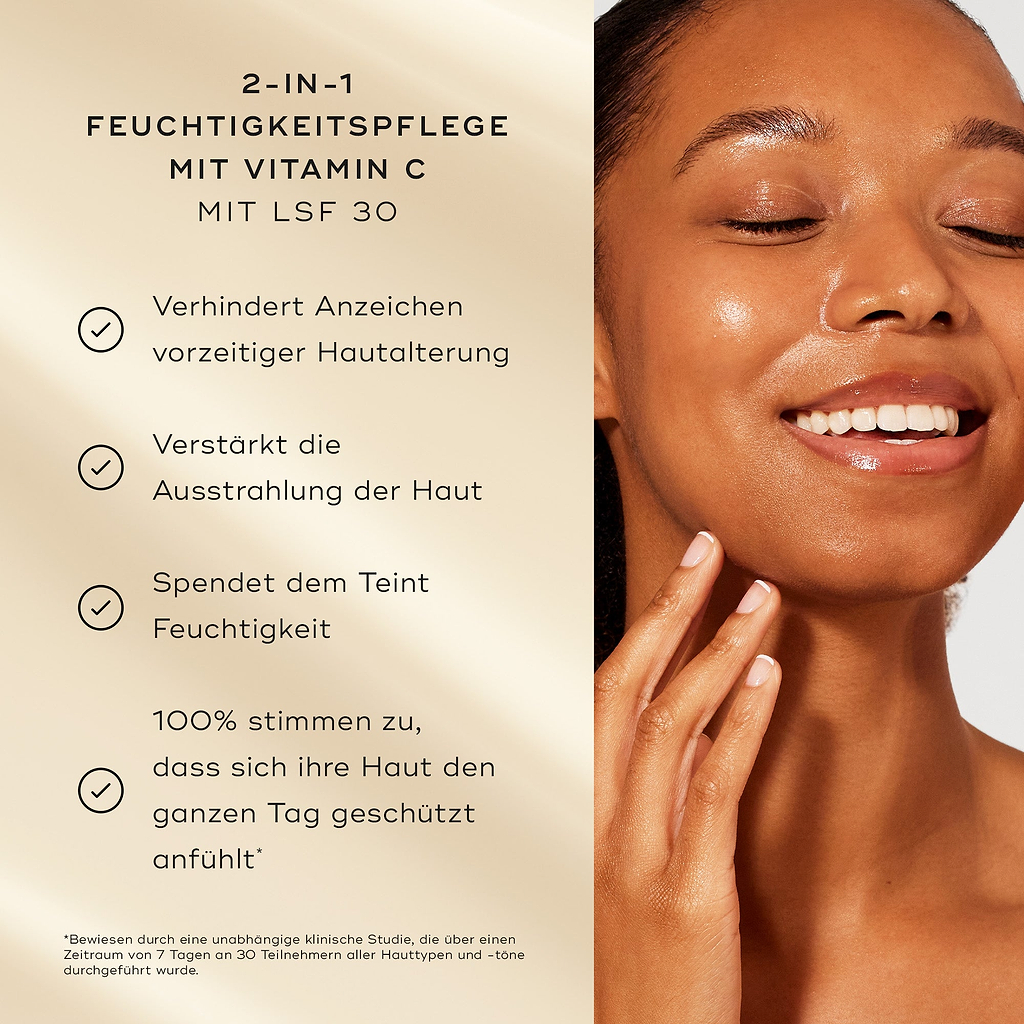 Ein Modell mit strahlender Haut lächelt neben einer Liste von Produktvorteilen auf einem sanft goldenen Hintergrund. Der Text hebt die 2-in-1 Vitamin C Feuchtigkeitscreme mit SPF 30 hervor: Verhindert Anzeichen vorzeitiger Hautalterung, steigert die Hautstrahlung, spendet Feuchtigkeit, 100 % stimmen zu, dass sich die Haut den ganzen Tag geschützt anfühlt.