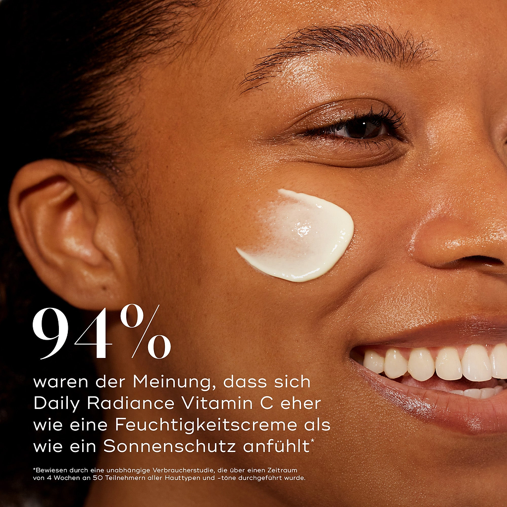 Nahaufnahme im Profil eines lächelnden Models mit einem Creme-Strich auf der Wange. Fettdruck weist darauf hin, dass 94 % der Anwender empfanden, dass Daily Radiance Vitamin C eher wie eine Feuchtigkeitscreme als ein Sonnenschutz wirkt