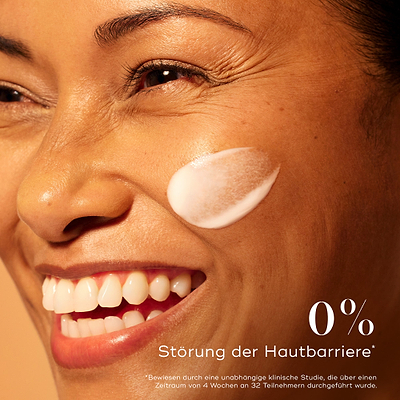 Lächelnde Frau mit strahlender Haut und einem Auftrag des Medik8 C-Tetra Advanced Serums auf der Wange, der 0 % Barrierestörung für sanfte, aber effektive Aufhellung betont.