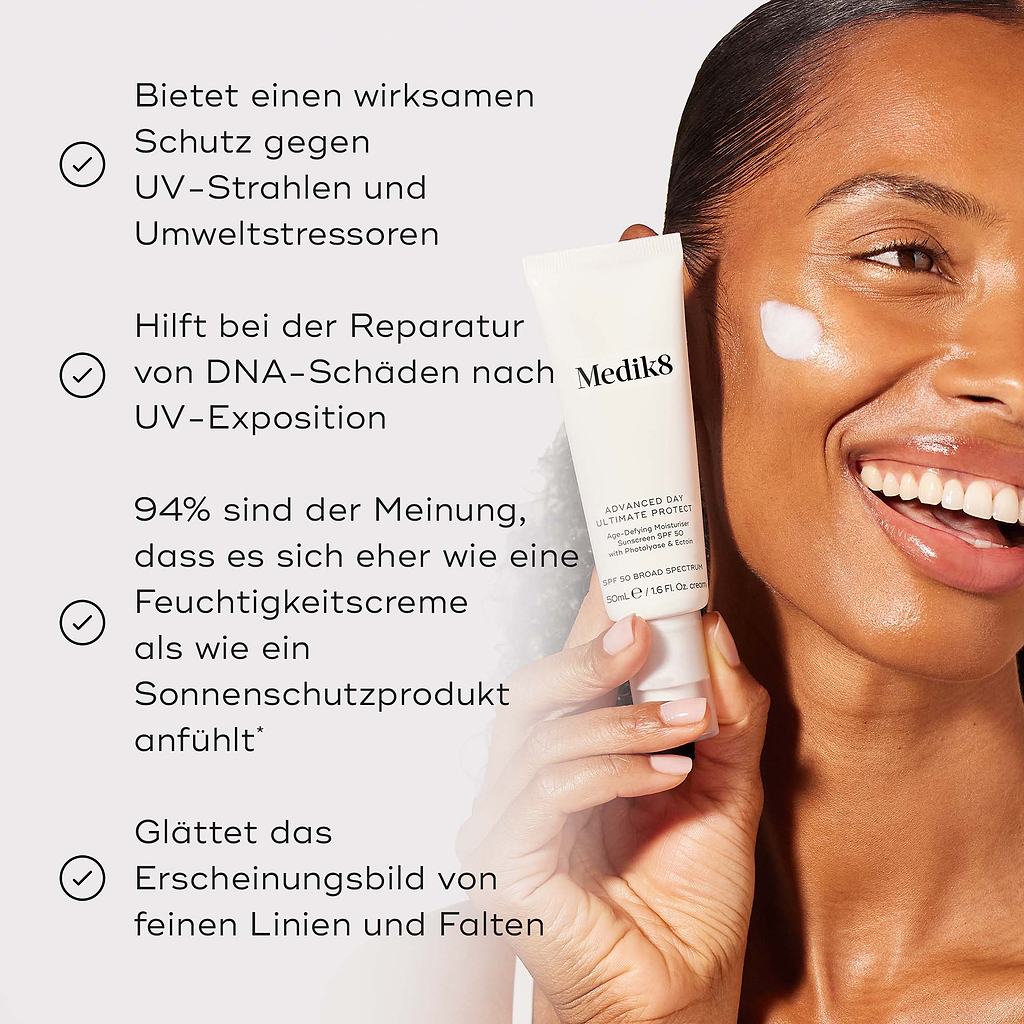 Die Tube der Medik8 Advanced Day Ultimate Protect Creme wird von einem lächelnden Model gehalten, mit einem Auftrag weißer Creme auf ihrer Wange vor warmem beigem Hintergrund. Der Text hebt vier Hauptvorteile hervor: kraftvoller Schutz vor UV-Strahlen und Umweltstressoren, Reparatur von DNA-Schäden nach UV-Exposition, 94 % stimmen zu, dass sie sich wie eine Feuchtigkeitscreme anfühlt, und 100 % erlebten kein Abrollen oder Pilling.