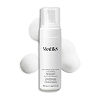 Botella con dispensador de Medik8 Calmwise Soothing Cleanser mostrada sobre un fondo blanco con una capa de espuma blanca detrás, destacando la textura del producto.