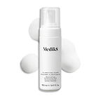 Botella con dispensador de Medik8 Clarifying Foam exhibida sobre un fondo blanco limpio junto a tres porciones de espuma blanca y ligera. El texto identifica el producto como un limpiador refrescante para imperfecciones con AHA/BHA de 150 mL.