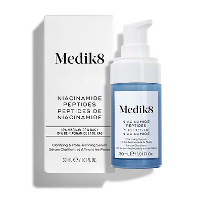 Sérum clarificante y refinador de poros con péptidos de niacinamida de Medik8, mostrado con su caja blanca de venta al público y un frasco con dosificador azul sobre un fondo blanco limpio.