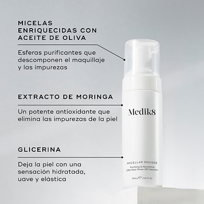 Una botella de Medik8 Micellar Mousse exhibida sobre un bloque blanco. Unas líneas conectan la botella con texto que explica los ingredientes clave: micelas infusionadas con aceite de oliva para descomponer el maquillaje, extracto de moringa para extraer las impurezas y glicerina para proporcionar hidratación.