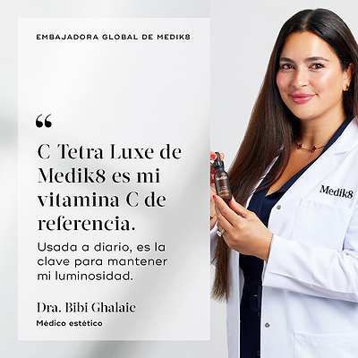 Dr. Bibi Ghalaie sonríe mientras lleva una bata de laboratorio blanca de Medik8 y sostiene una botella marrón de C-Tetra Luxe. A su lado aparece una cita que dice: «C-Tetra Luxe de Medik8 es mi vitamina C de referencia. Utilizada a diario, es la clave para mantener mi luminosidad».
